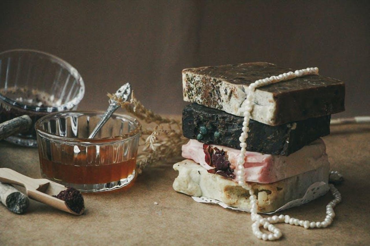 Ingredienti_chiave_del_prodotto_BcpzGNqebf - Confidenze24 Source: Seferikalbiye - pexels - A stack of rustic handmade soap bars with natural ingredients and honey in a cozy setting.