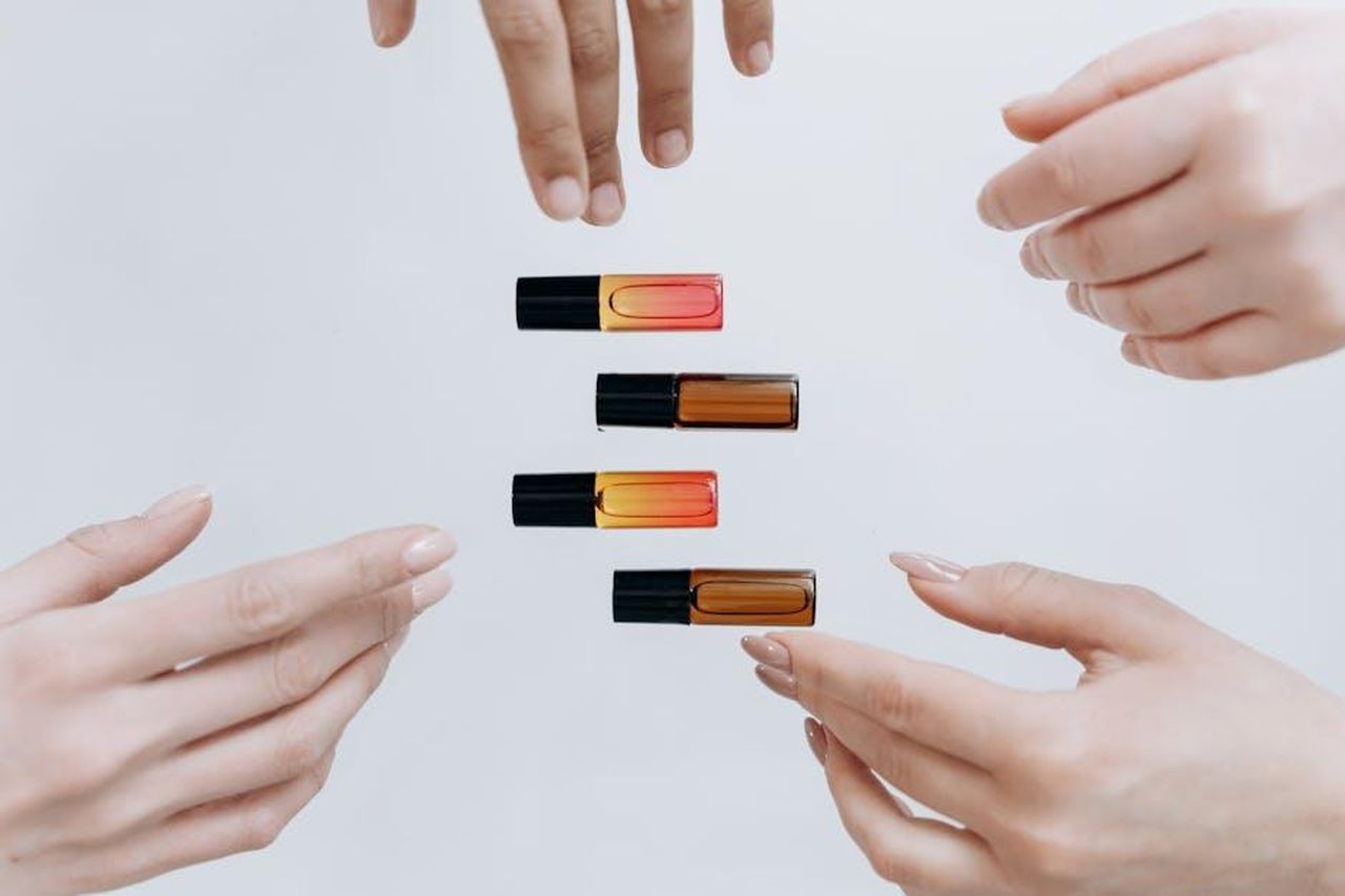 Ingredienti_chiave_e_benefici_eXfYY23775 - Confidenze24 Source: Mikhail Nilov - pexels - Hands gracefully displaying a set of colorful essential oil bottles.