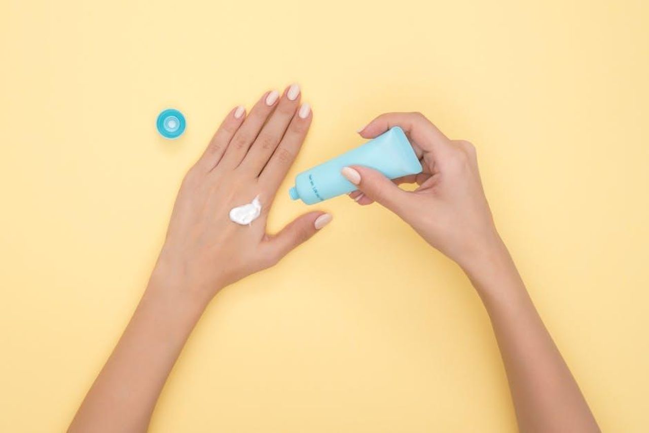 Ingredienti_e_benefici_del_Seaweed_Night_Cream_HyxpRITXXE - Confidenze24 Source: Moose Photos - pexels - Close-up of a woman's hands applying cream on a pastel yellow background. Ideal for beauty and skincare themes.