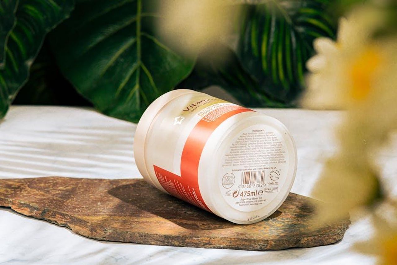 Ingredienti_e_benefici_della_Crema_Ricca_dflCrQaTe0 - Confidenze24 Source: Đậu Lu - pexels - Skincare product jar on a marble surface surrounded by lush green leaves.