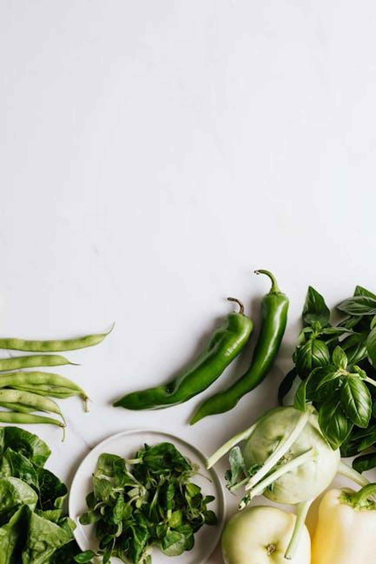 Ingredienti_e_tecnologia_della_crema_Dr_Brandt_UjnkEGzTiS - Confidenze24 Source: Photo By: Kaboompics.com - pexels - A selection of fresh green vegetables arranged artfully on a white background, perfect for healthy lifestyle concepts.