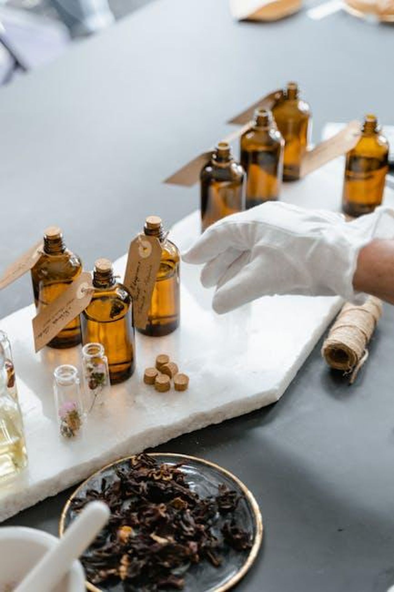 Ingredienti_idratanti_e_benefici_per_la_pelle_tkMjA8aiuj - Confidenze24 Source: MART PRODUCTION - pexels - Elegant display of amber bottles and dried herbs for aromatherapy on a marble slab.