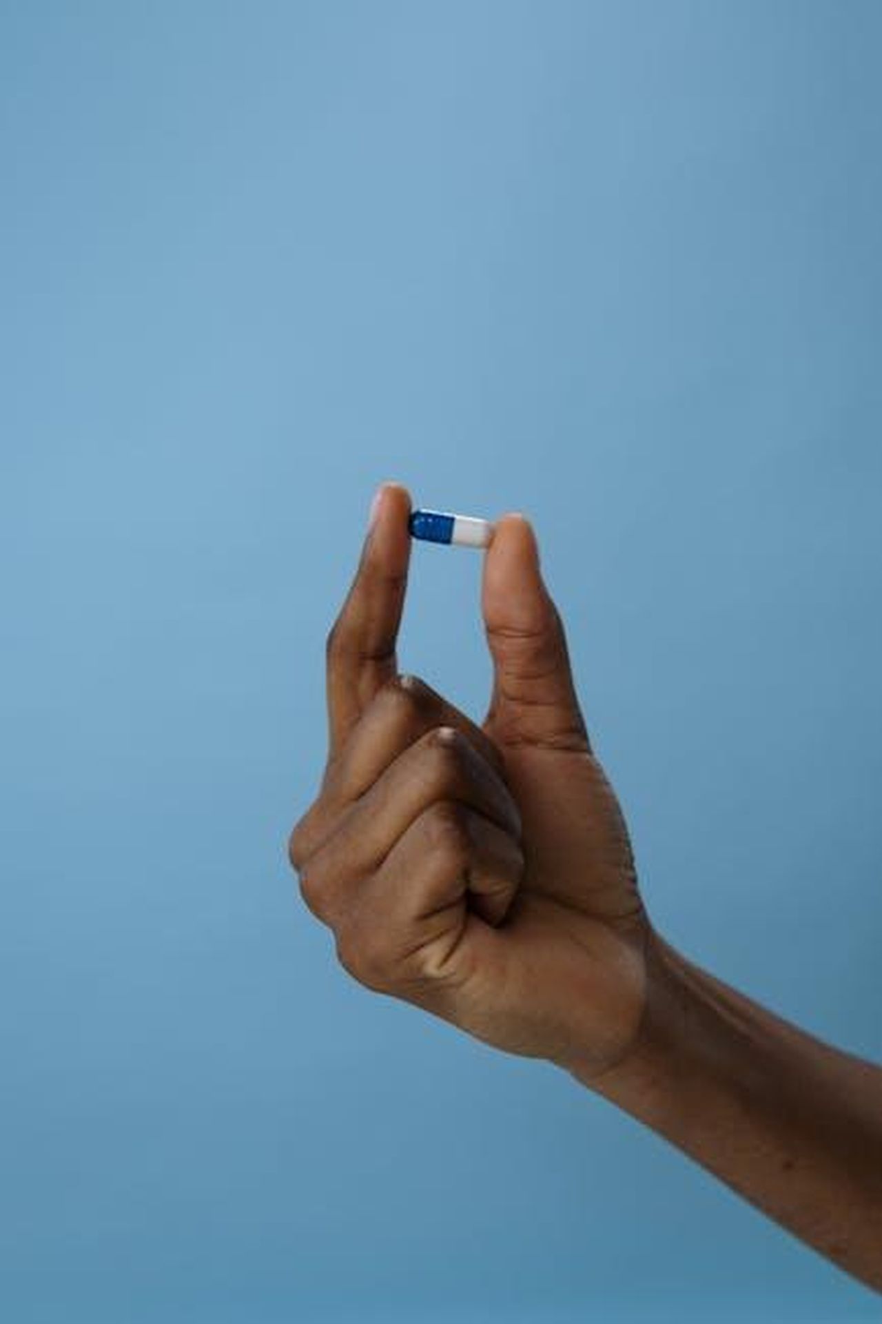 Iniziare_Presto_per_Evitare_le_Allergie_Primaverili_KRzf0YEES1 - Confidenze24 Source: cottonbro studio - pexels - Close-up of a hand holding a blue and white capsule against a plain background. Ideal for medical themes.