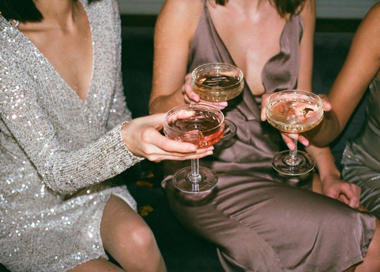 Innovazioni_nel_Menu_e_Nuove_Bevande_maV13px2Ro - Confidenze24 Source: Inga Seliverstova - pexels - Three women in stylish dresses toasting with champagne at a festive gathering.