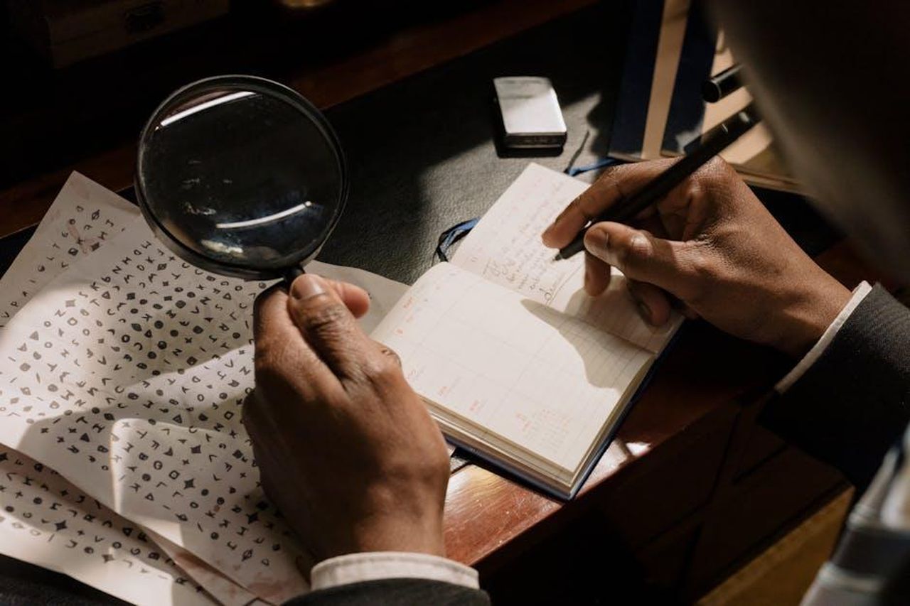 Ispirazioni_per_il_personaggio_di_Cordelia_iikmeIzTpO - Confidenze24 Source: cottonbro studio - pexels - A detective decoding cipher documents with a magnifying glass, notebook in hand.