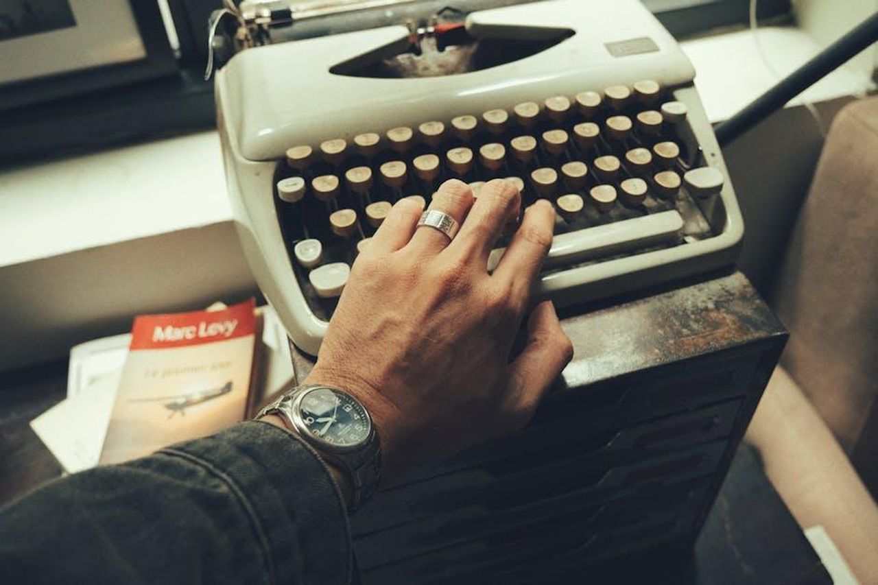 Iwan_Carrington_ha_scritto_un_libro_XVBT92V5Ys - Confidenze24 Source: Việt Anh Nguyễn - pexels - Close-up of a hand on a vintage typewriter, evocative of nostalgia and creativity.