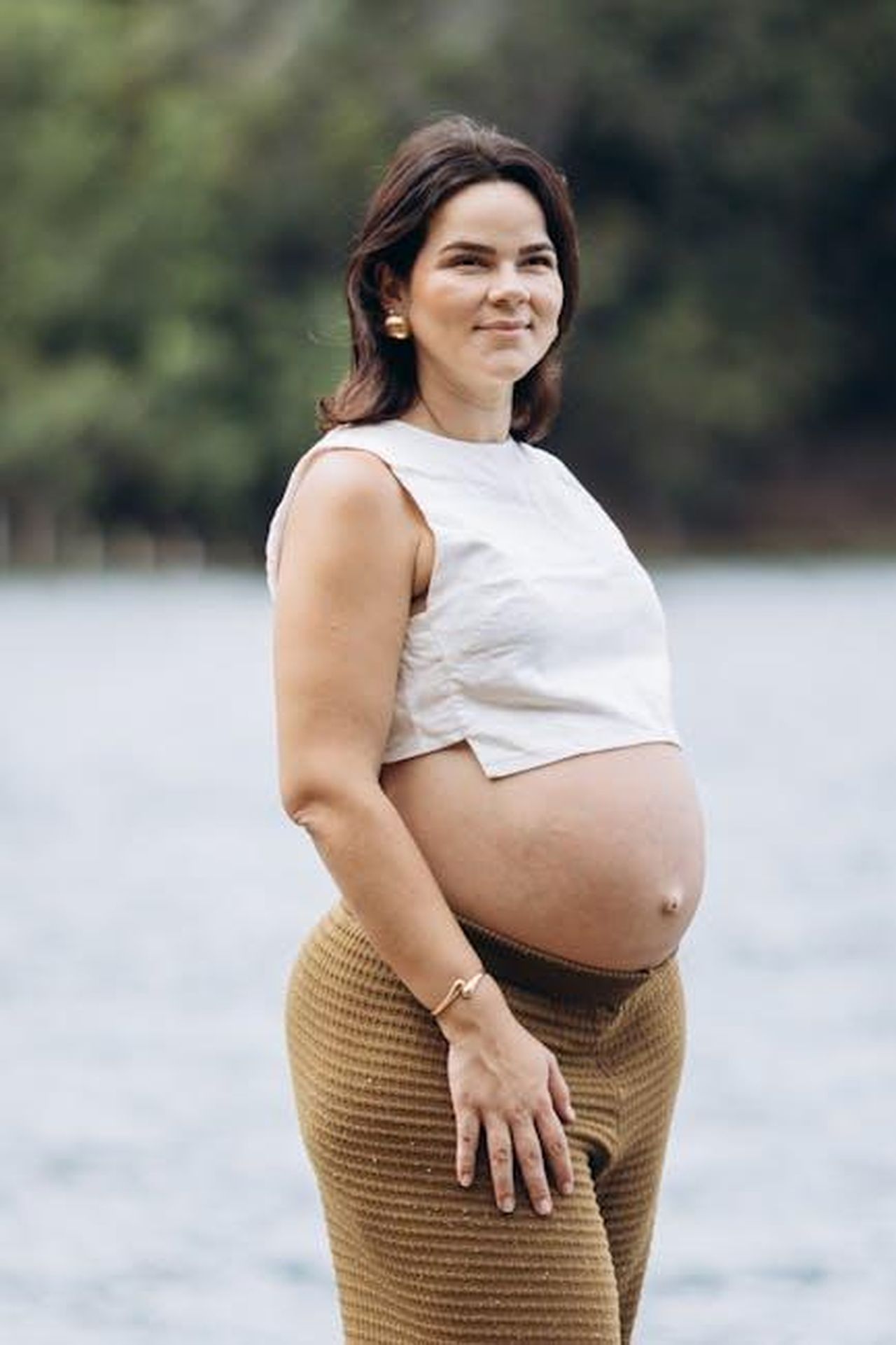 Jackiey_attacca_di_nuovo_3grWL4bp5x - Confidenze24 Source: Jonathan Borba - pexels - Pregnant woman smiling by a serene lake, showcasing maternity beauty.