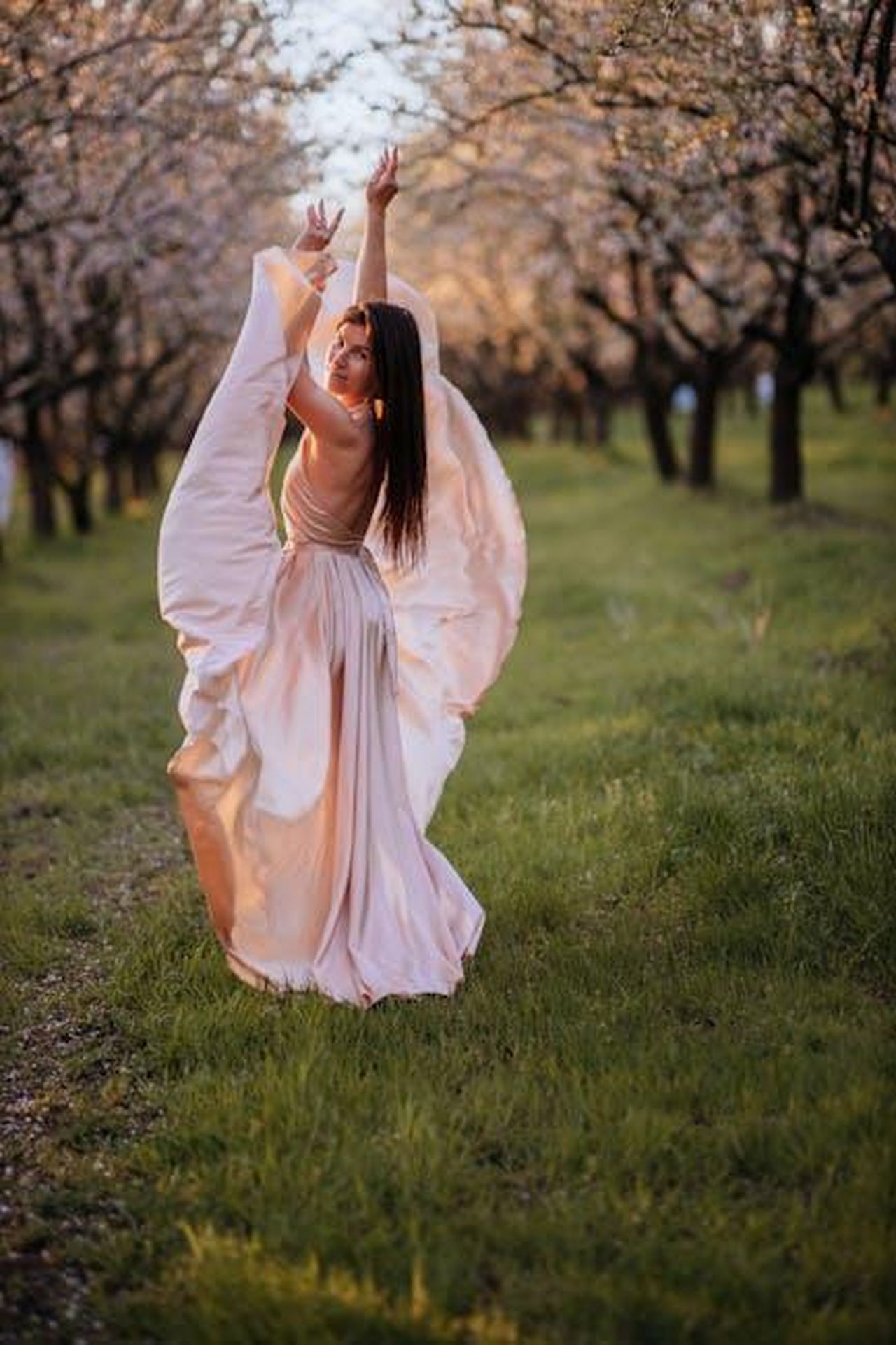 Jackiey_esclusa_dalle_performance_di_Bobby_ev1UIuMC4w - Confidenze24 Source: Galina Kolonitskaia - pexels - A graceful woman in a flowing satin dress twirls among blossoming trees during spring.