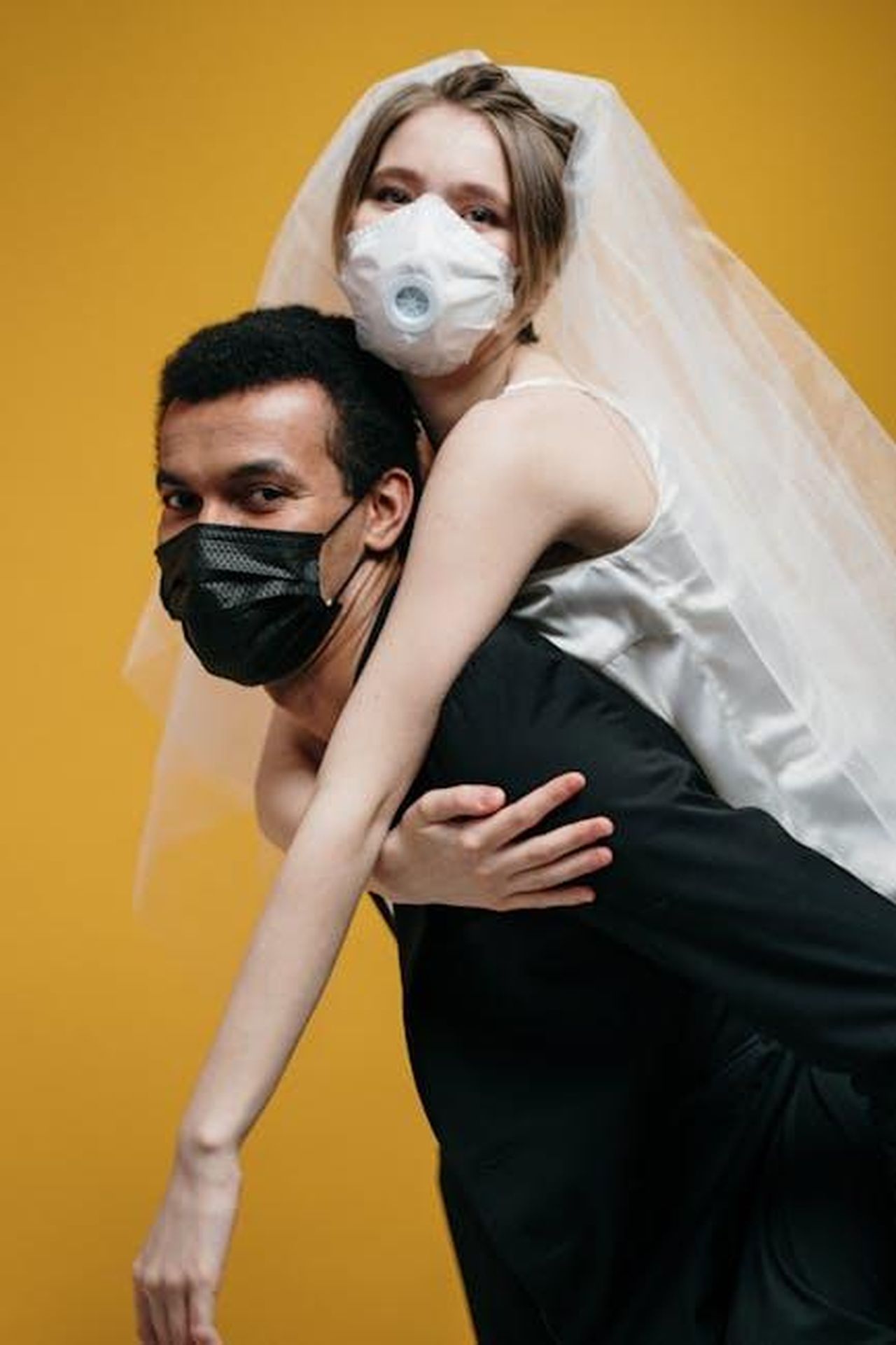 James_affronta_un_problema_di_salute_jq31eXG4LQ - Confidenze24 Source: cottonbro studio - pexels - A bride and groom wearing masks embrace in a playful pose, symbolizing love during the pandemic.