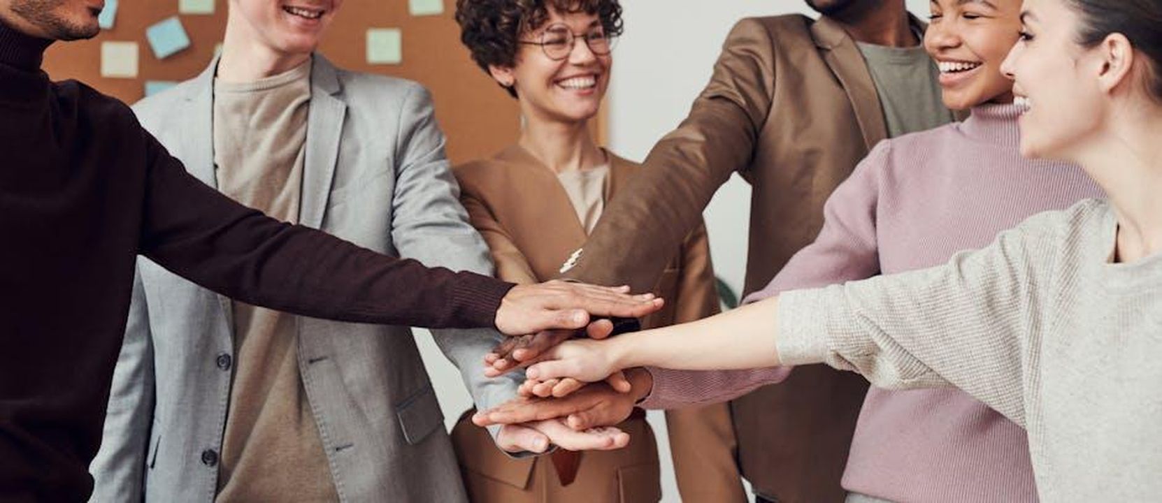 Jeff_desidera_collaborare_con_Jackiey_R4BhHYm111 - Confidenze24 Source: fauxels - pexels - A group of happy, diverse colleagues celebrating teamwork and cooperation with a group high five indoors.