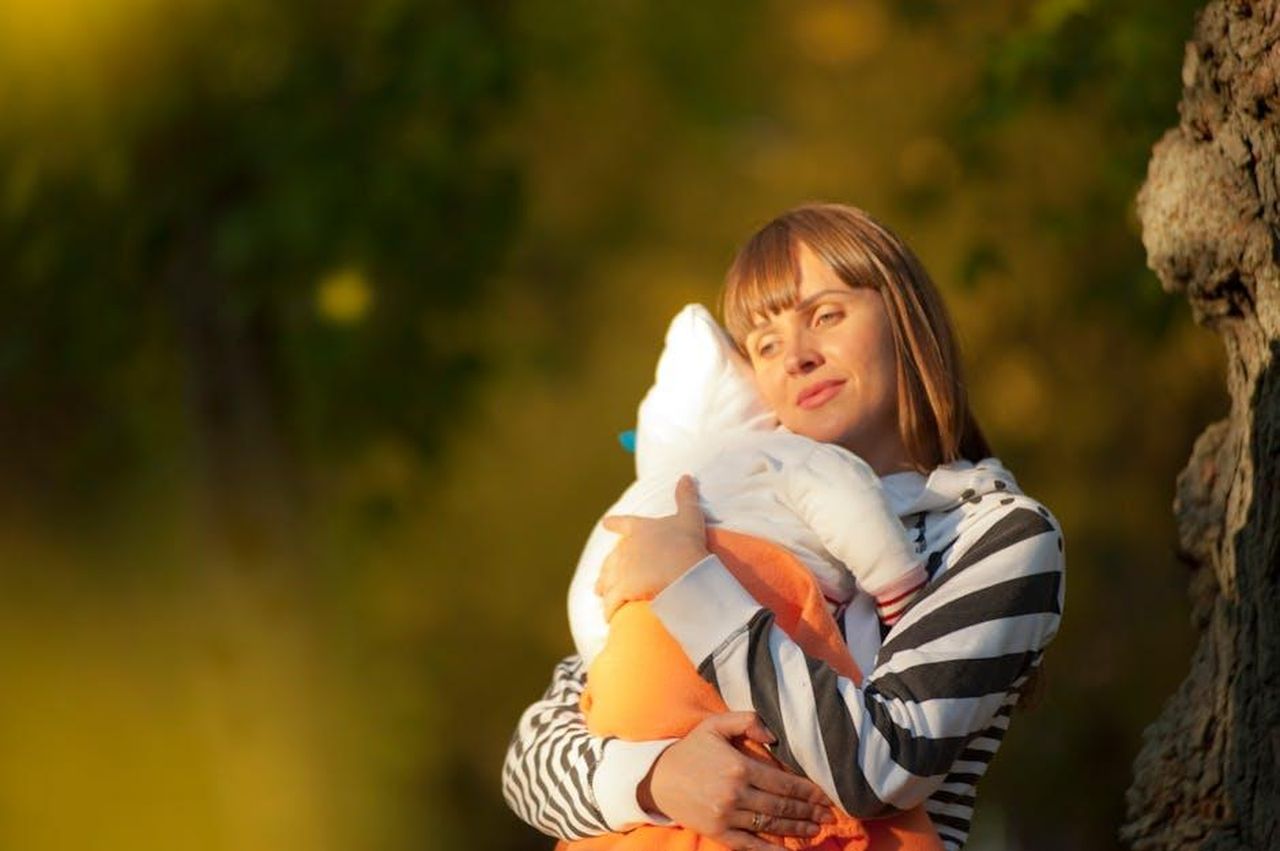 Jenna_parla_della_maternit_SUlFexqKJ7 - Confidenze24 Source: Alex P - pexels - A serene moment of a mother cuddling her baby outdoors during the day.