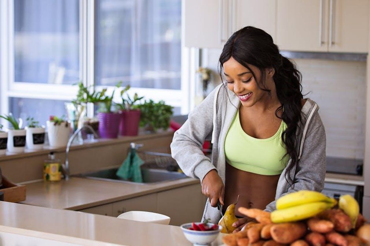 Jillie_Mack_il_supporto_alla_salute_di_Tom_Selleck_JykEi4T4Hl - Confidenze24 Source: Nathan Cowley - pexels - Smiling woman preparing fresh fruit in a sunlit kitchen, embodying a healthy lifestyle.