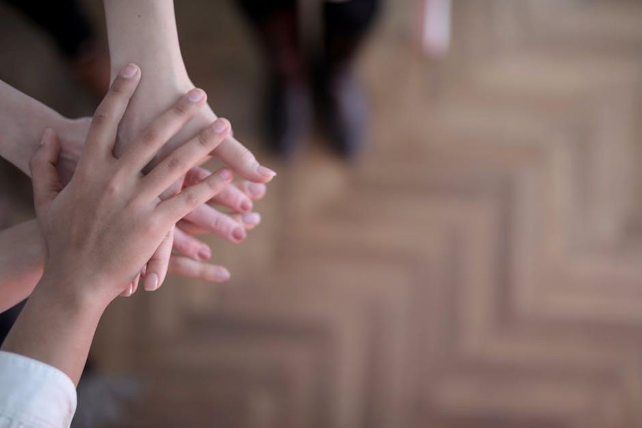 Josie_Gibson_mostra_il_suo_supporto_XZWoBKxr3K - Confidenze24 Source: Andrea Piacquadio - pexels - Hands stacked showing teamwork and unity from a top view indoors.