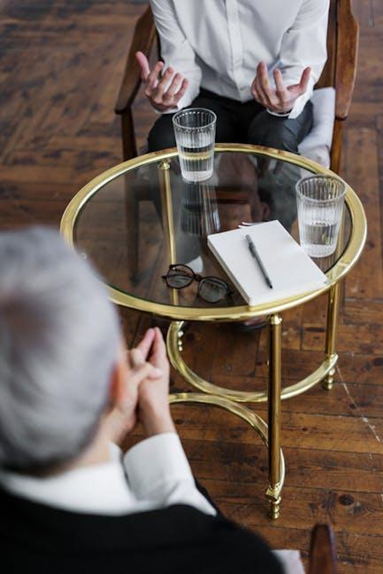 Justine_e_le_sue_esperienze_dopo_il_divorzio_YeVl9adoZt - Confidenze24 Source: cottonbro studio - pexels - Two adults discussing mental health in a counseling session across a glass table indoors.