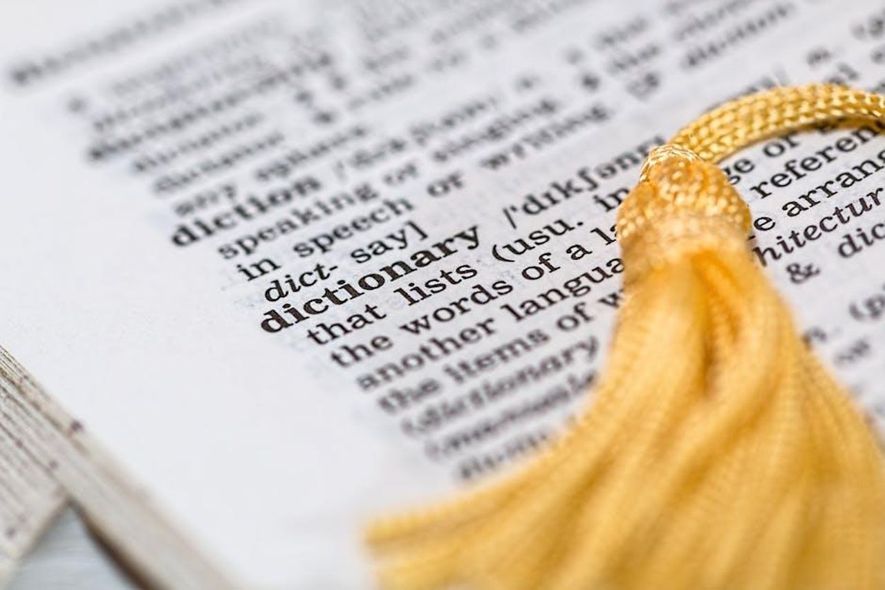 Kate_e_lapp_Duolingo_gsM35MlY8m - Confidenze24 Source: Pixabay - pexels - Close-up image of a dictionary page focused on the word 'dictionary' with a yellow tassel.