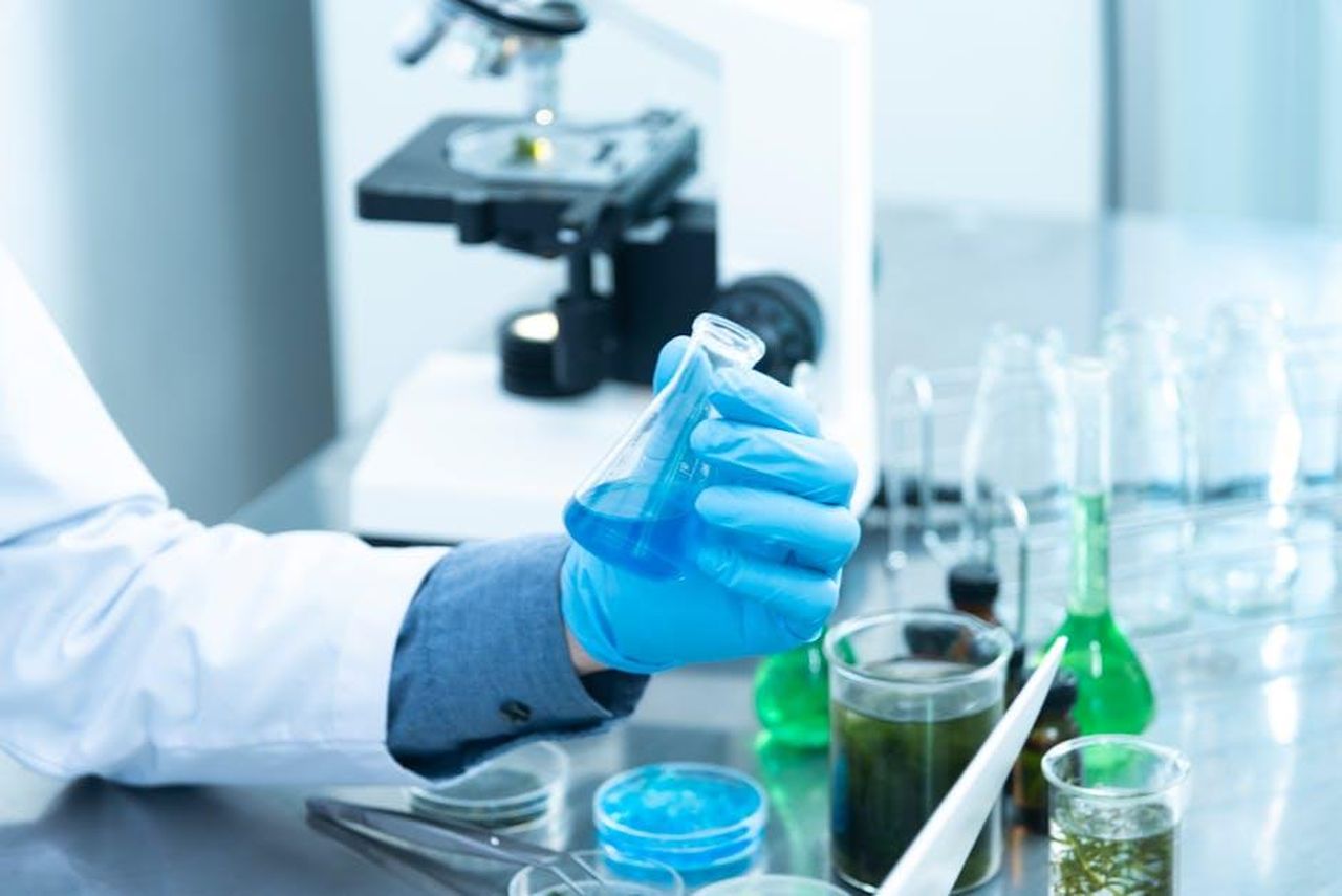 Kennedy_parla_dei_benefici_del_vaccino_MMR_bmbLBH2tlz - Confidenze24 Source: Chokniti Khongchum - pexels - Scientist in gloves analyzing blue liquid in a laboratory setting with microscope and glassware.