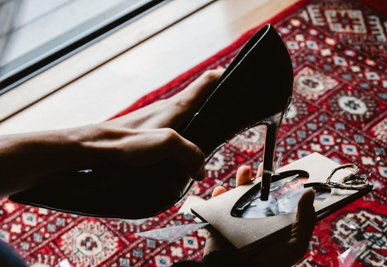 LaTocha_rivela_dettagli_sulla_sua_separazione_f1IJyXMIpI - Confidenze24 Source: RDNE Stock project - pexels - A black high heel stiletto piercing a heart-shaped photo on a vibrant Persian rug.