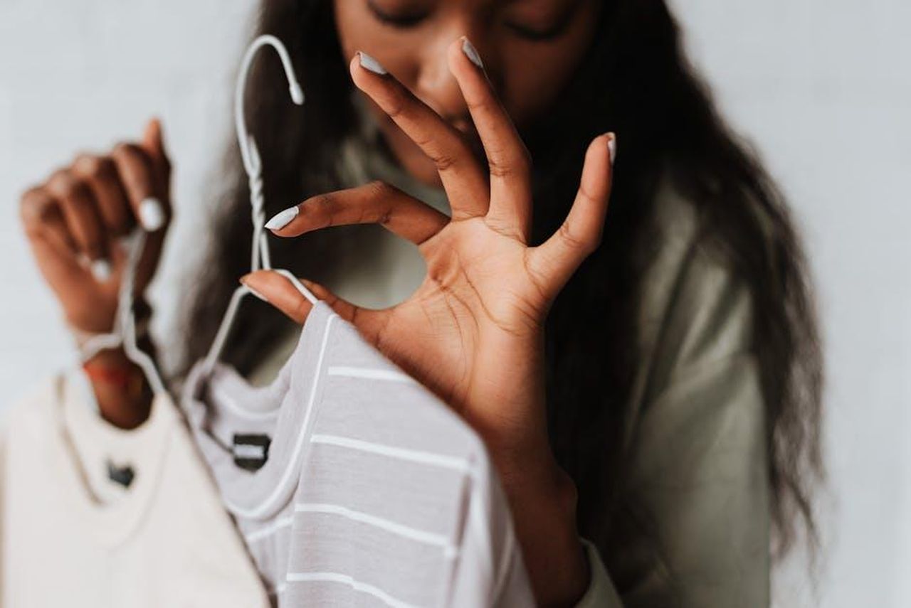 La_Fine_di_unEra_per_Good_Bones_z3IhxOFzzc - Confidenze24 Source: Anete Lusina - pexels - Crop young African American female with wear on hangers demonstrating good gesture on light background