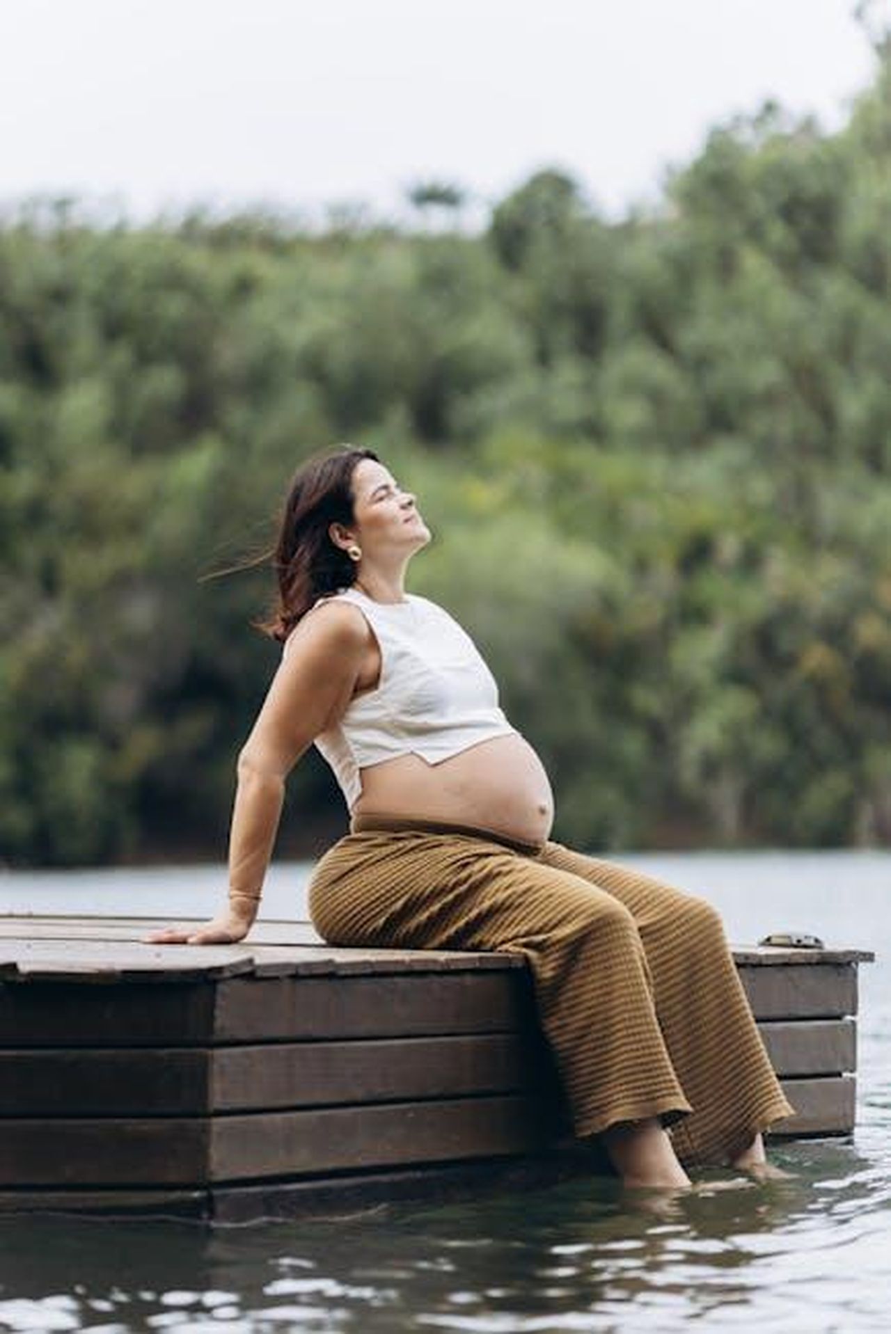 La_Lotta_Contro_il_Razzismo_nella_Musica_f6fBJsY0N7 - Confidenze24 Source: Jonathan Borba - pexels - A serene moment of a pregnant woman enjoying nature by a lake.