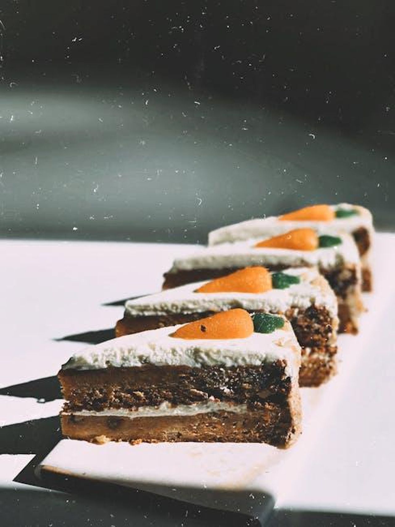 La_Torta_di_Carote_torna_da_Costco_gT0ikKONOX - Confidenze24 Source: chudesabyvaut - pexels - Close-up of carrot cake slices topped with cream cheese frosting and marzipan carrots on a white plate.