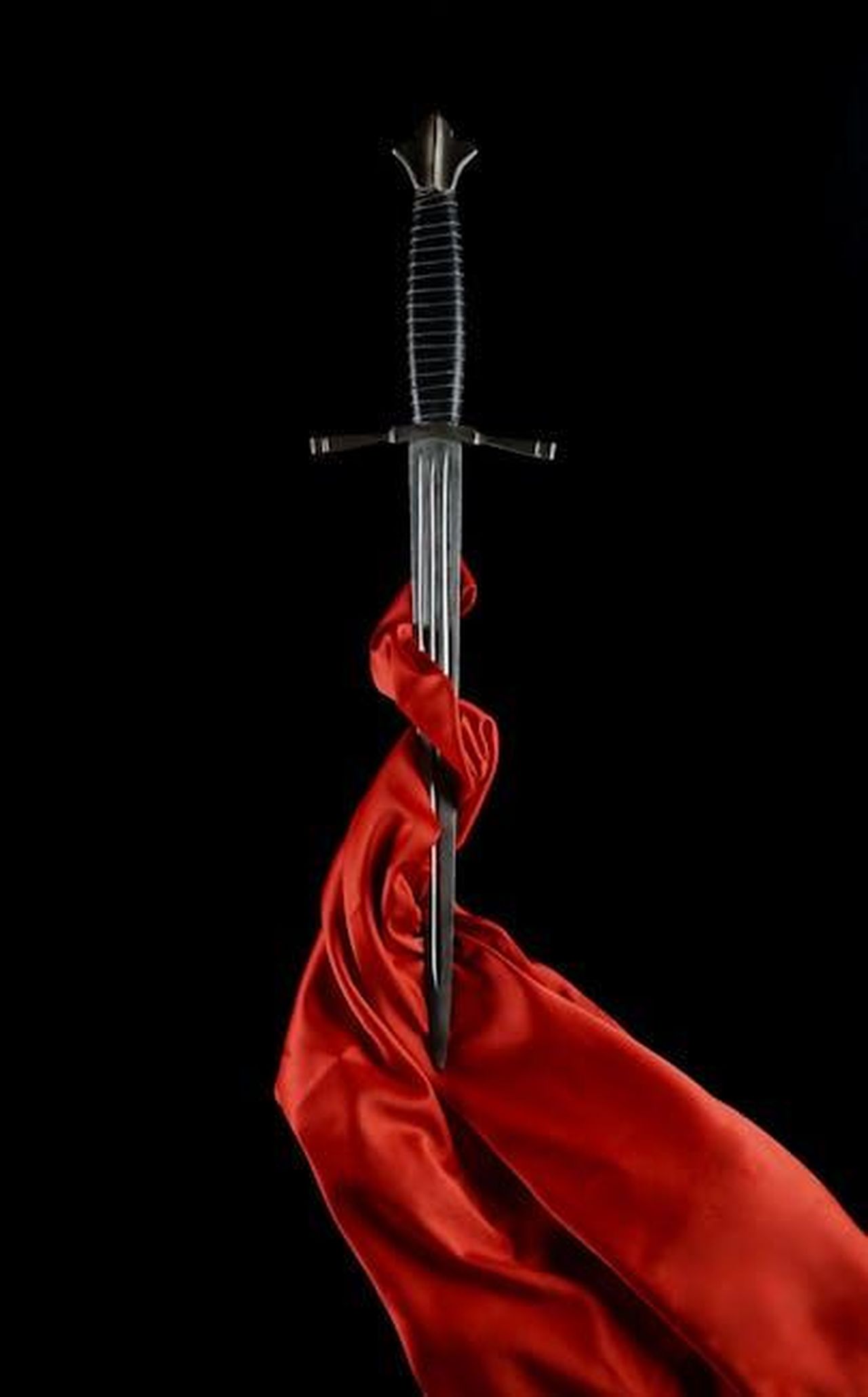 La_battaglia_per_la_custodia_e_le_preoccupazioni_di_sicurezza_xFrqEY65cY - Confidenze24 Source: Maria Pop - pexels - A striking still life of a medieval sword wrapped in red silk, set against a black background.
