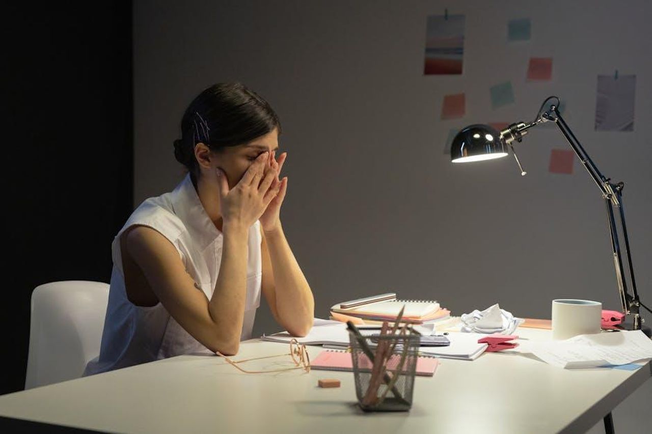 La_battuta_di_Sophie_sulla_sua_vita_con_un_workaholic_30D2bDRDai - Confidenze24 Source: cottonbro studio - pexels - A stressed businesswoman rubs her eyes at a cluttered desk, overwhelmed by work.