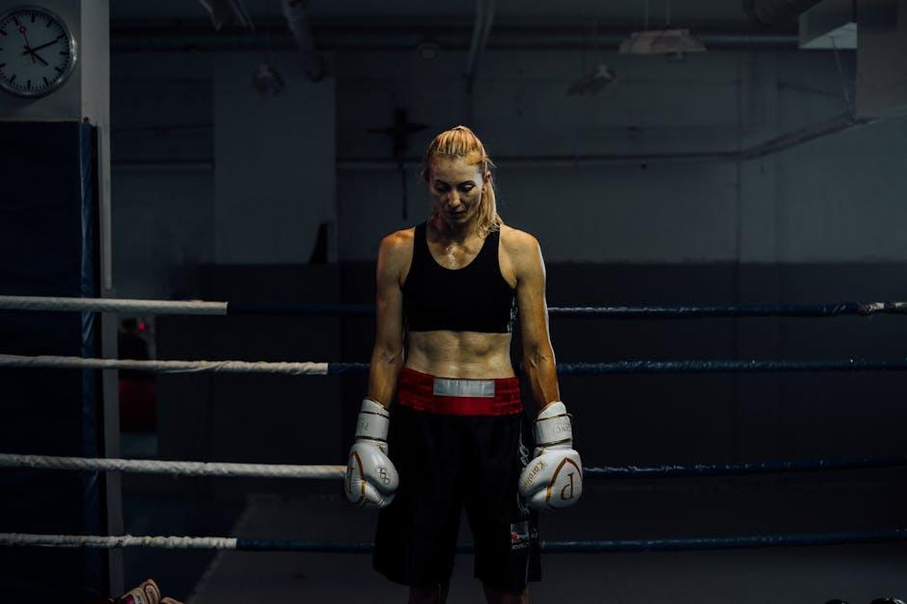 La_carriera_di_George_Foreman_zZAp9CDTbV - Confidenze24 Source: KoolShooters - pexels - Focused female boxer standing in a gym boxing ring, ready for intense training.