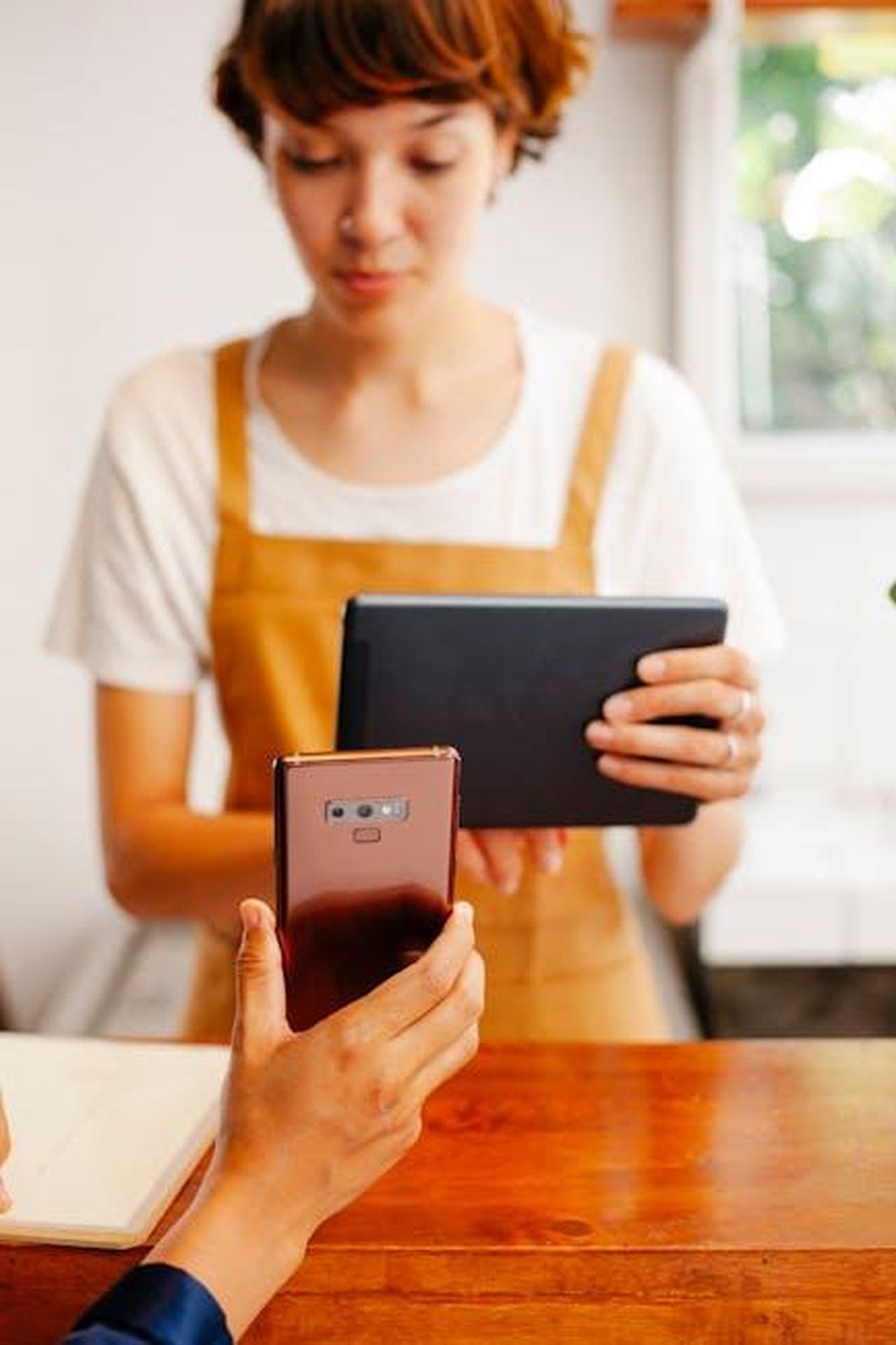 La_chimica_tra_Mark_e_Kelly_drP4PwkXwX - Confidenze24 Source: Tim Douglas - pexels - Two women using a smartphone and tablet in a bright indoor setting.