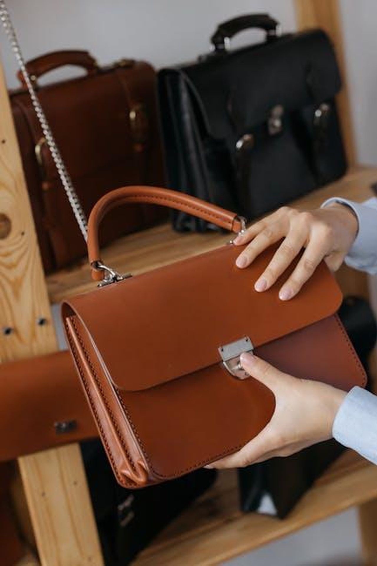 La_collezione_di_Herms_di_Cardi_B_YTwpV8GSTX - Confidenze24 Source: cottonbro studio - pexels - A stylish leather handbag being presented in a sleek, modern showroom setting.