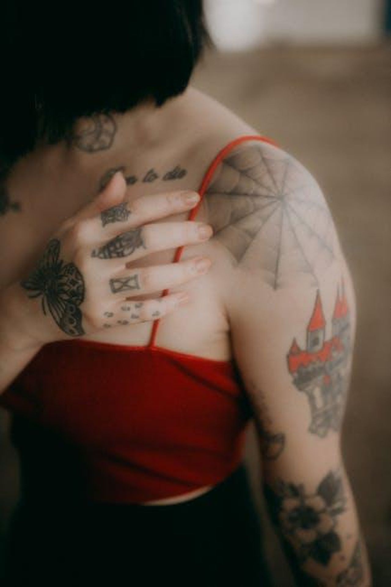 La_collezione_di_tatuaggi_di_Paris_Jackson_WRTlUE6hdP - Confidenze24 Source: Alexander Mass - pexels - Close-up of a tattooed woman in red with an obscured face, artistic pose.