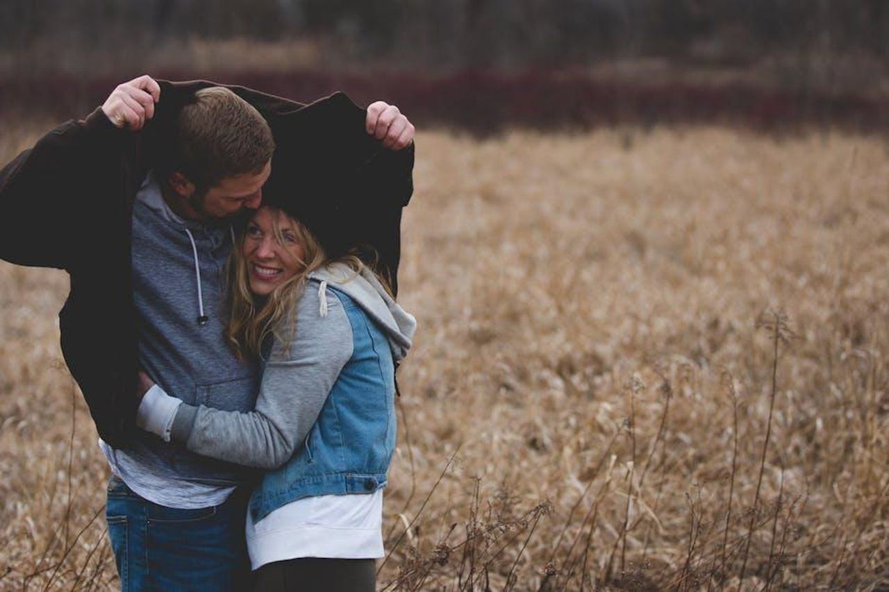 La_complessit_della_relazione_tra_Unique_e_Raq_3EnFFAV48N - Confidenze24 Source: Josh Willink - pexels - A couple shares a warm embrace under a coat in a rustic autumn field, expressing love and togetherness.