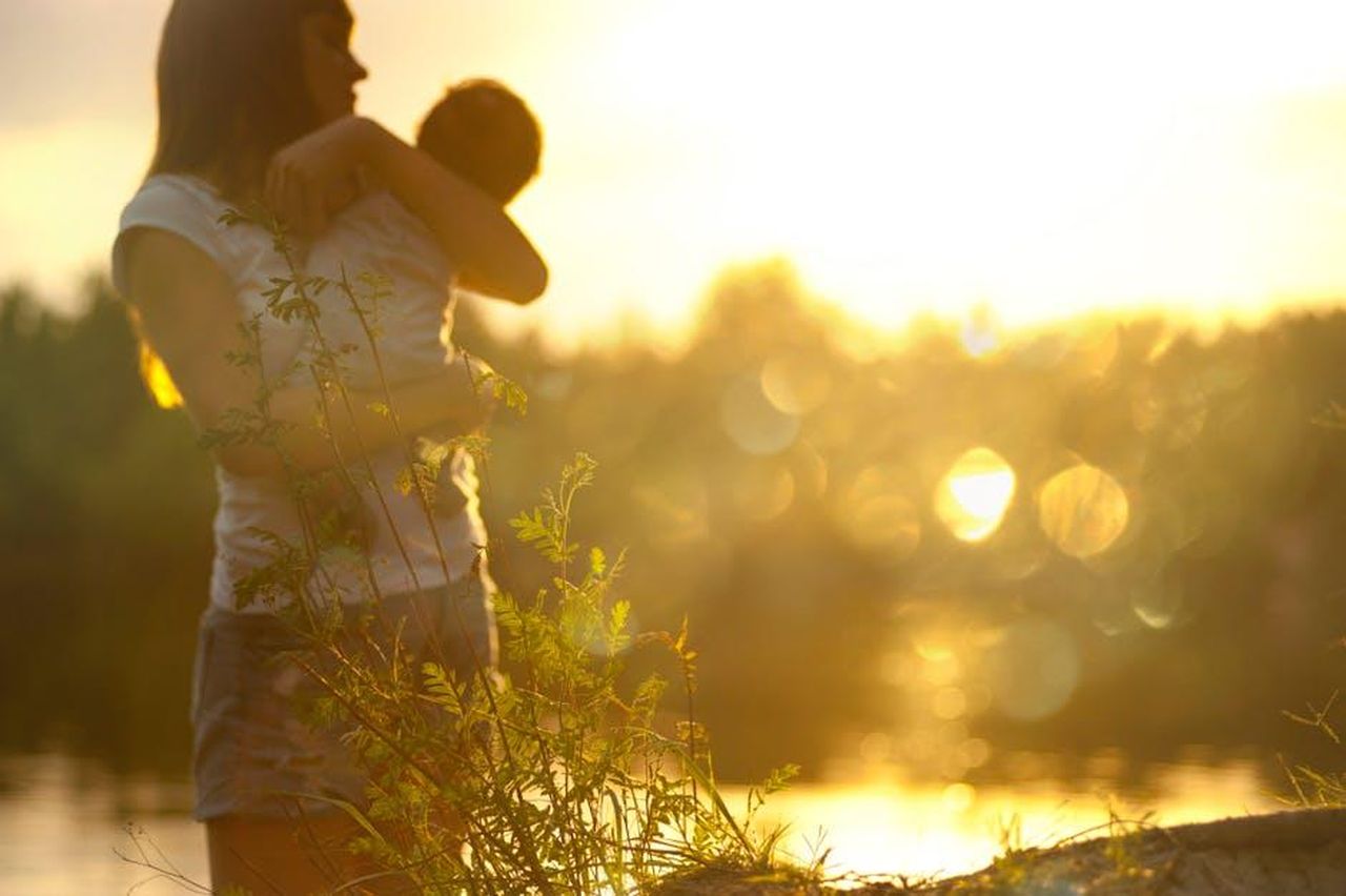 La_decisione_di_Hoda_di_lasciare_Today_QWNkJL2ERA - Confidenze24 Source: Alex P - pexels - A serene moment of a mother holding her baby at sunset by a lake.