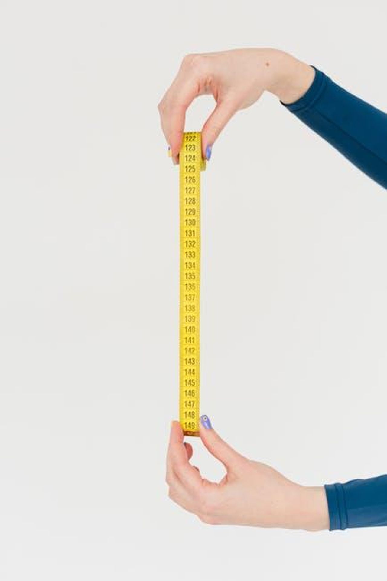 La_durata_della_settima_stagione_B1t1KekMhY - Confidenze24 Source: SHVETS production - pexels - Hands holding a yellow measuring tape on a white background, symbolizing precision.