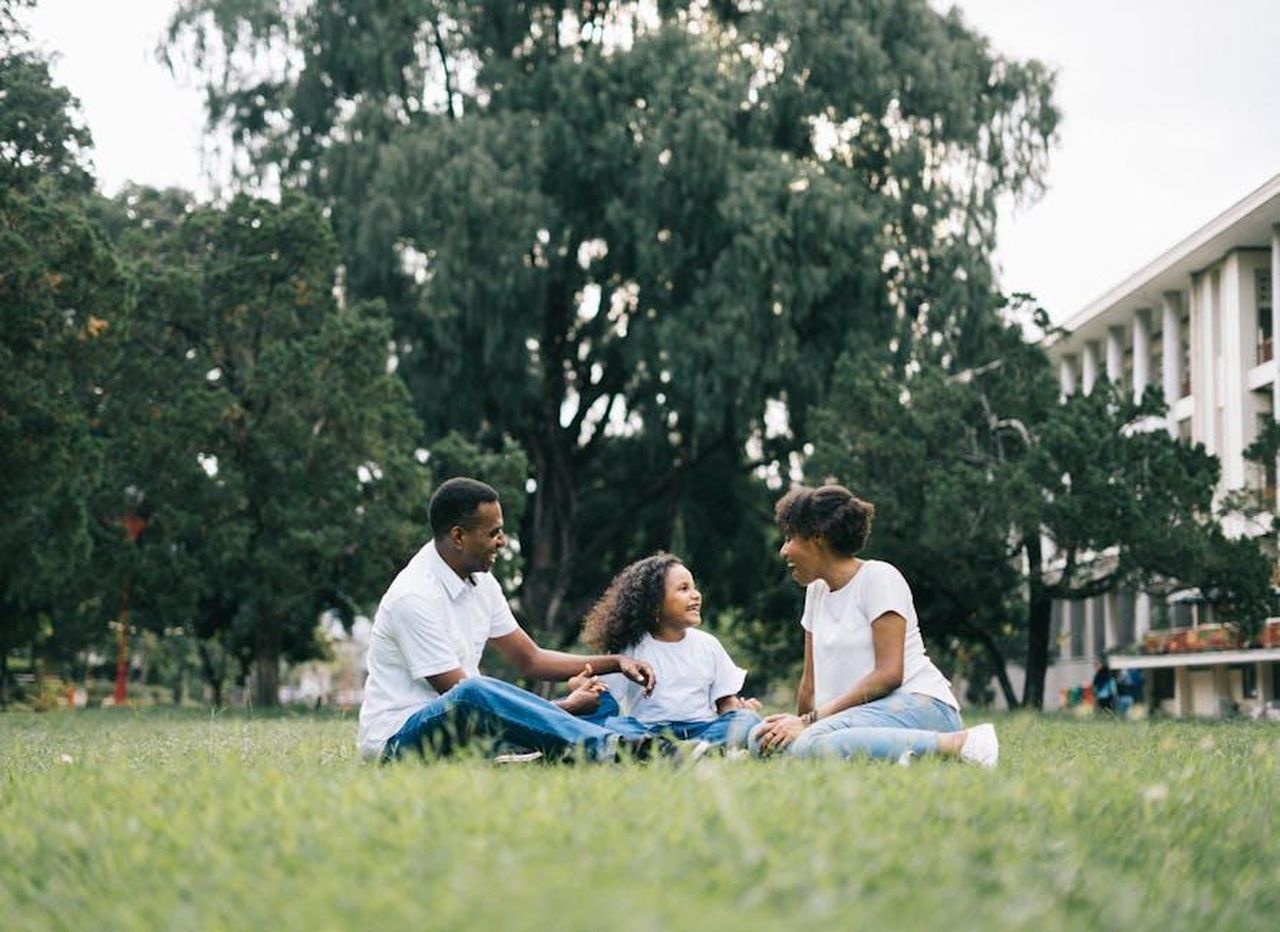 La_famiglia_Mahomes_AmsUCsLvqd - Confidenze24 Source: Agung Pandit Wiguna - pexels - A happy black family enjoying quality time together outdoors in a lush green park.