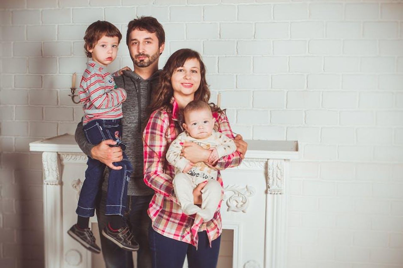 La_famiglia_di_Chris_Pratt_e_il_suo_percorso_di_fede_YUQNlgf69F - Confidenze24 Source: Vika Glitter - pexels - A joyful family posing together in a cozy living room, embodying love and togetherness.