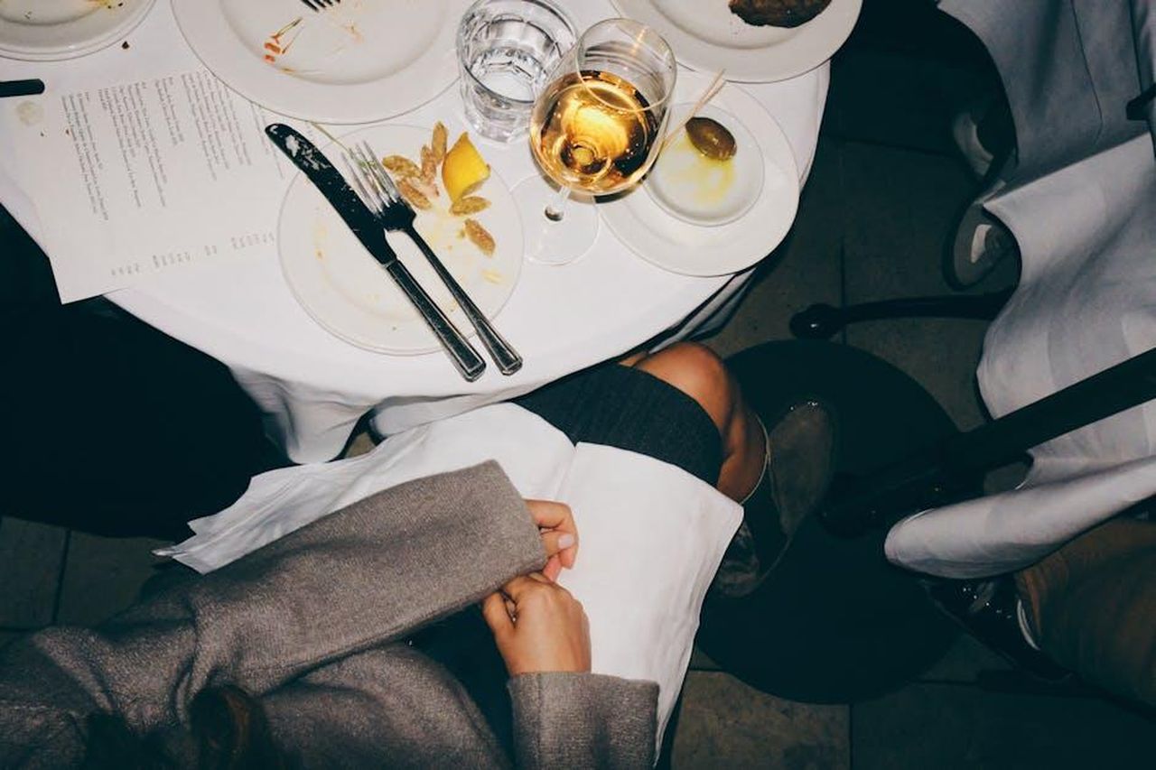 La_festa_di_pasta_con_gli_amici_15liA7HIBO - Confidenze24 Source: gravity cut - pexels - A top-down view of a dining table with elegant table setting and a glass of white wine.