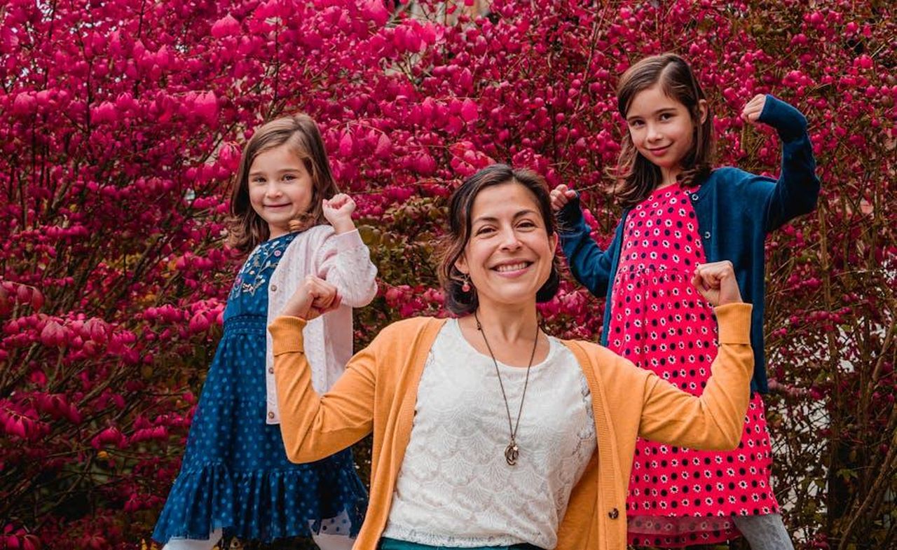 La_forza_delle_figlie_di_Vanessa_IHh1HUnoRR - Confidenze24 Source: Sofia Shultz - pexels - Mother and daughters joyfully posing in a colorful garden, symbolizing family unity.