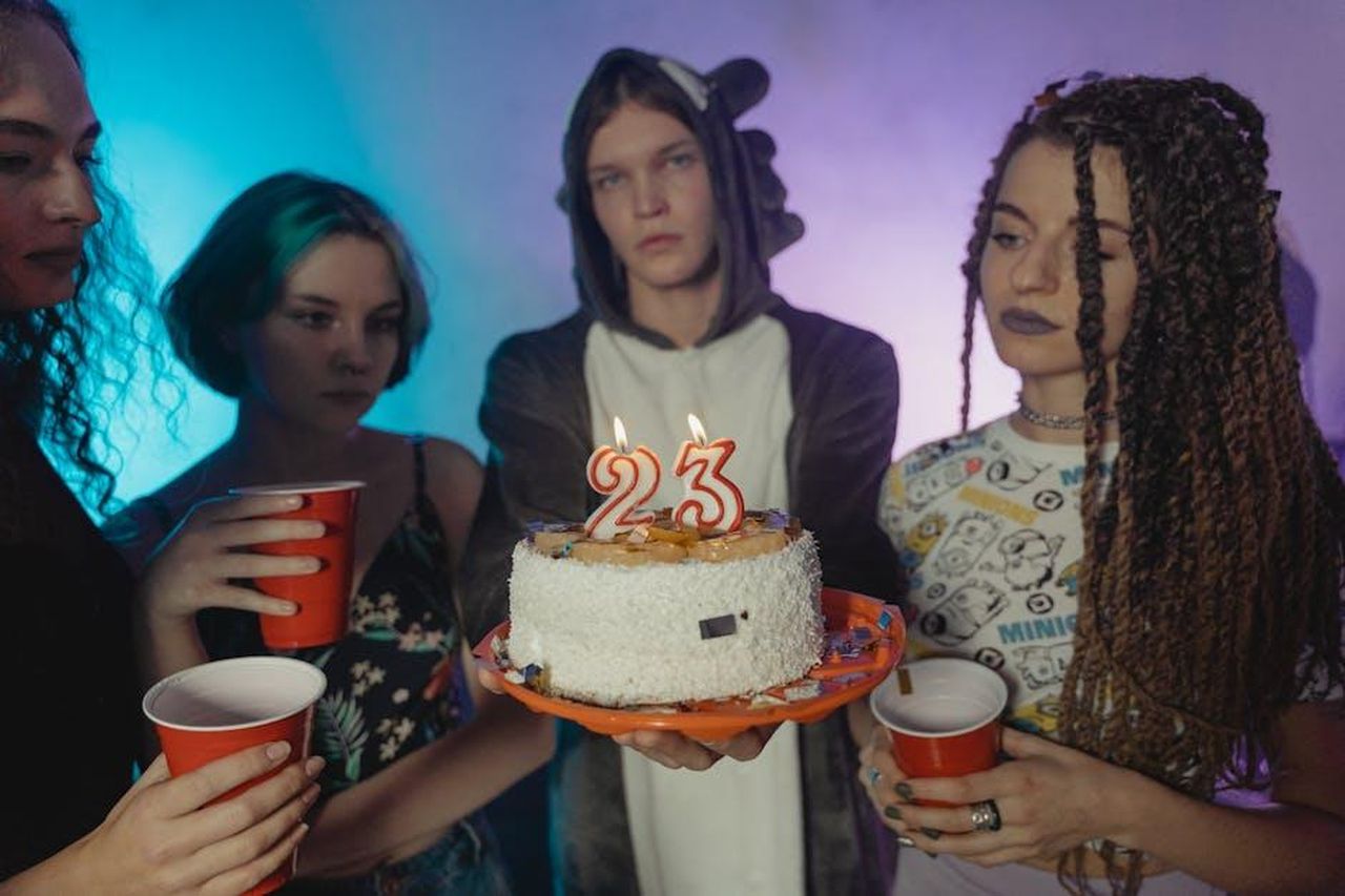 La_gioia_della_festa_e_i_dettagli_n1lv4bLEWw - Confidenze24 Source: Tima Miroshnichenko - pexels - Group of friends celebrating a 23rd birthday with cake and candles indoors.