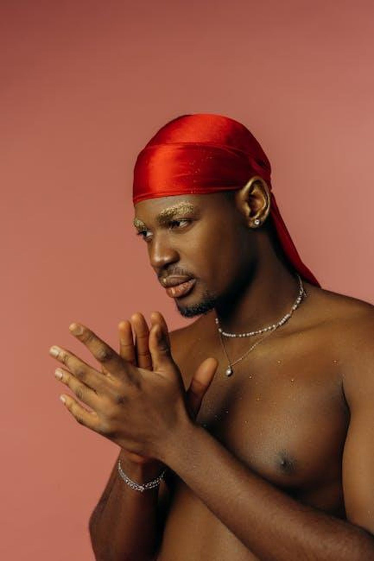 La_mascolinit_vera_contro_la_mascolinit_tossica_X453Z5Rtik - Confidenze24 Source: Mikhail Nilov - pexels - Portrait of a young man with a red headscarf, showcasing elegance against a warm background.
