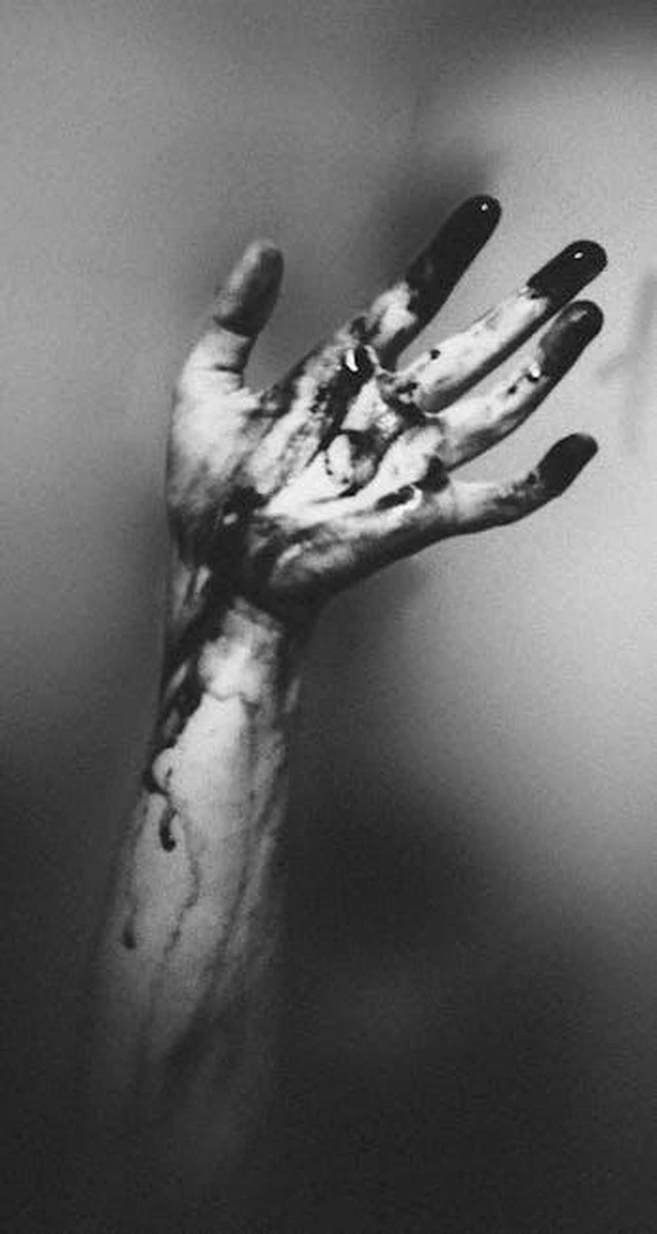 La_morte_assistita_non__unopzione_per_Esther_5hQ4vqluKG - Confidenze24 Source: Elīna Arāja - pexels - A monochrome image of an outstretched hand with dark liquid dripping, creating a dramatic and moody atmosphere.