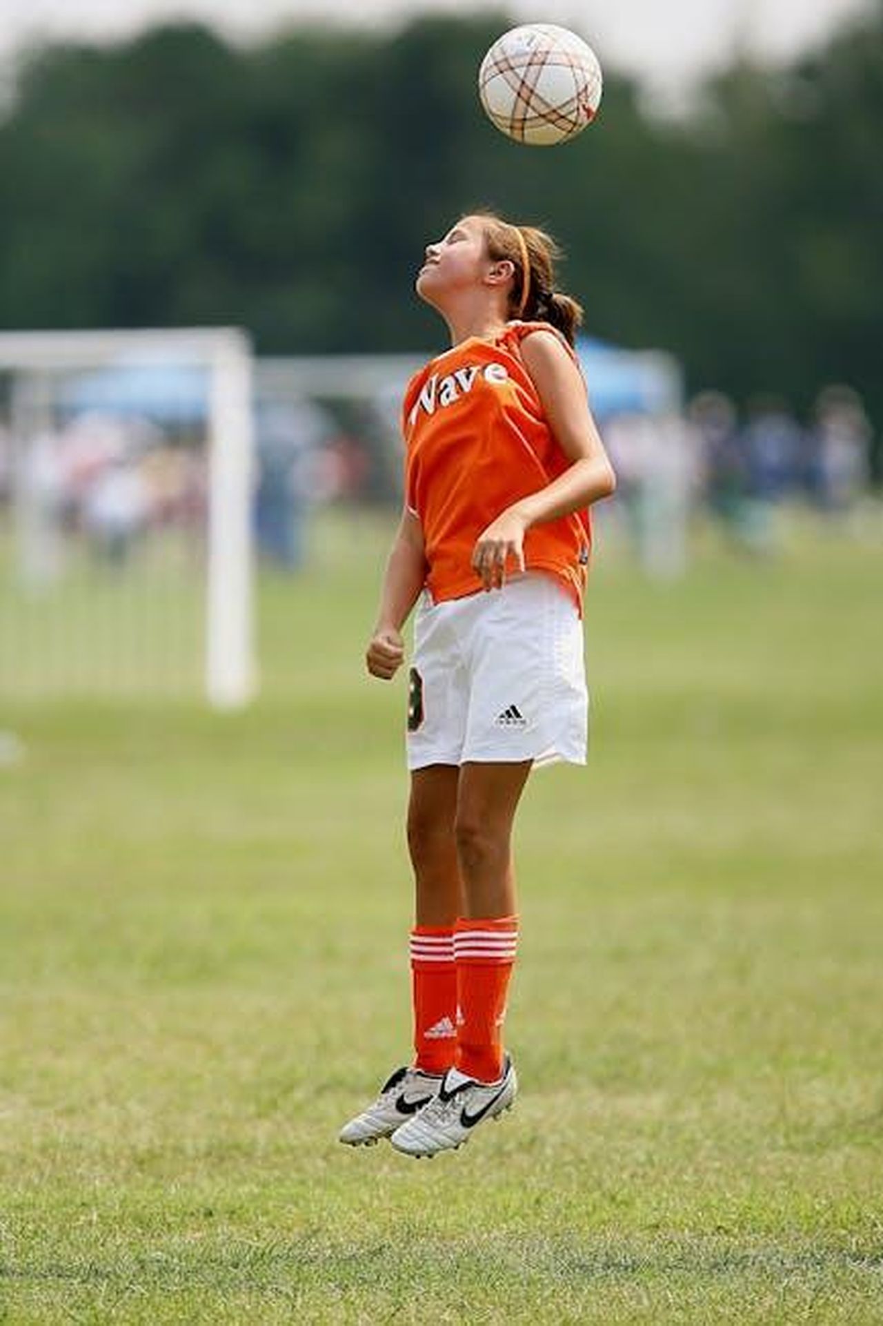 La_passione_dei_giovani_reali_Kt0OZ9LvkQ - Confidenze24 Source: Pixabay - pexels - A young girl jumps to head a soccer ball during a game on a grassy field.