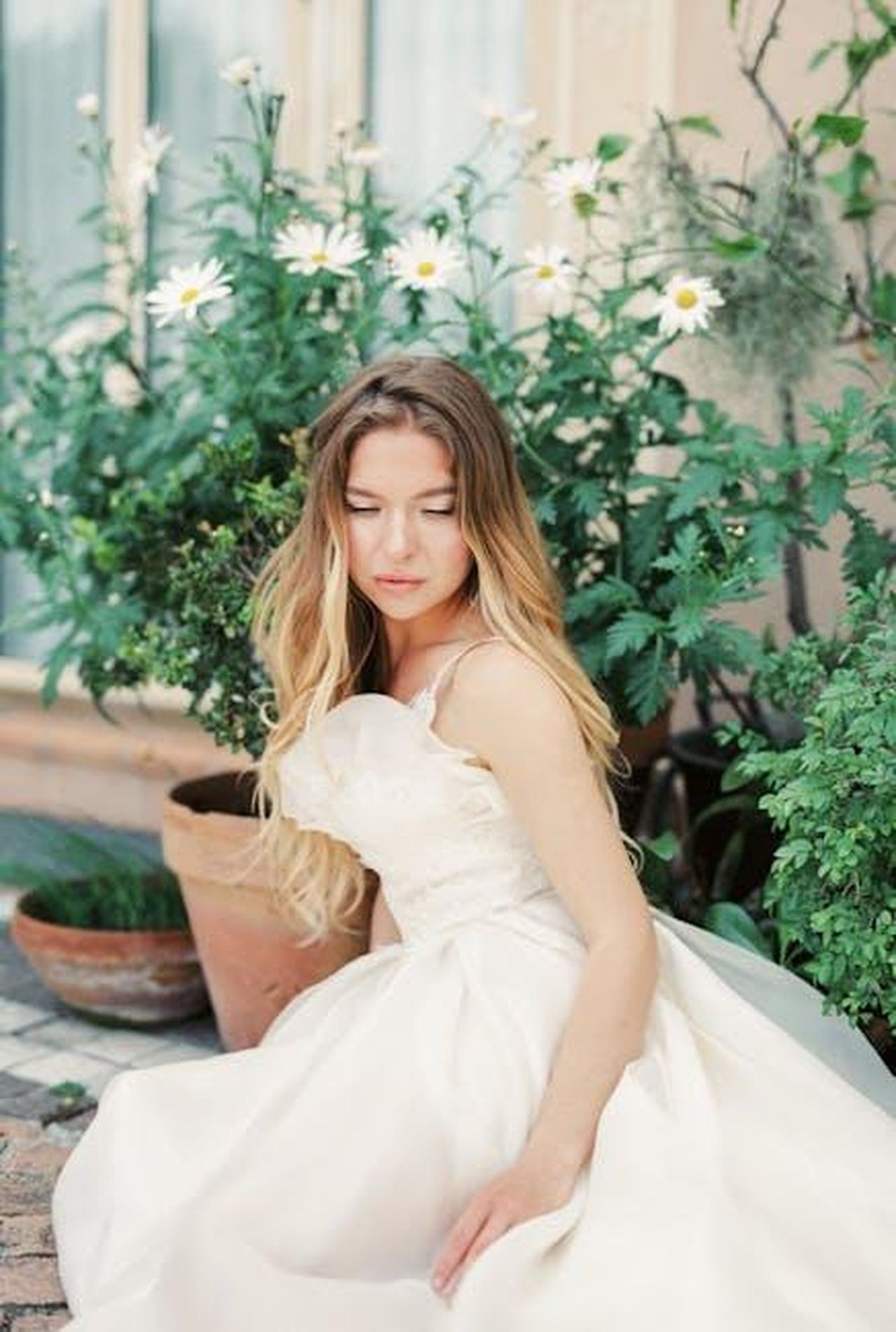 La_paura_di_Frankie_riguardo_al_vestito_da_sposa_PpTxZ2IE4I - Confidenze24 Source: Leeloo The First - pexels - A beautiful bride in a wedding dress sitting gracefully in a garden with daisies.