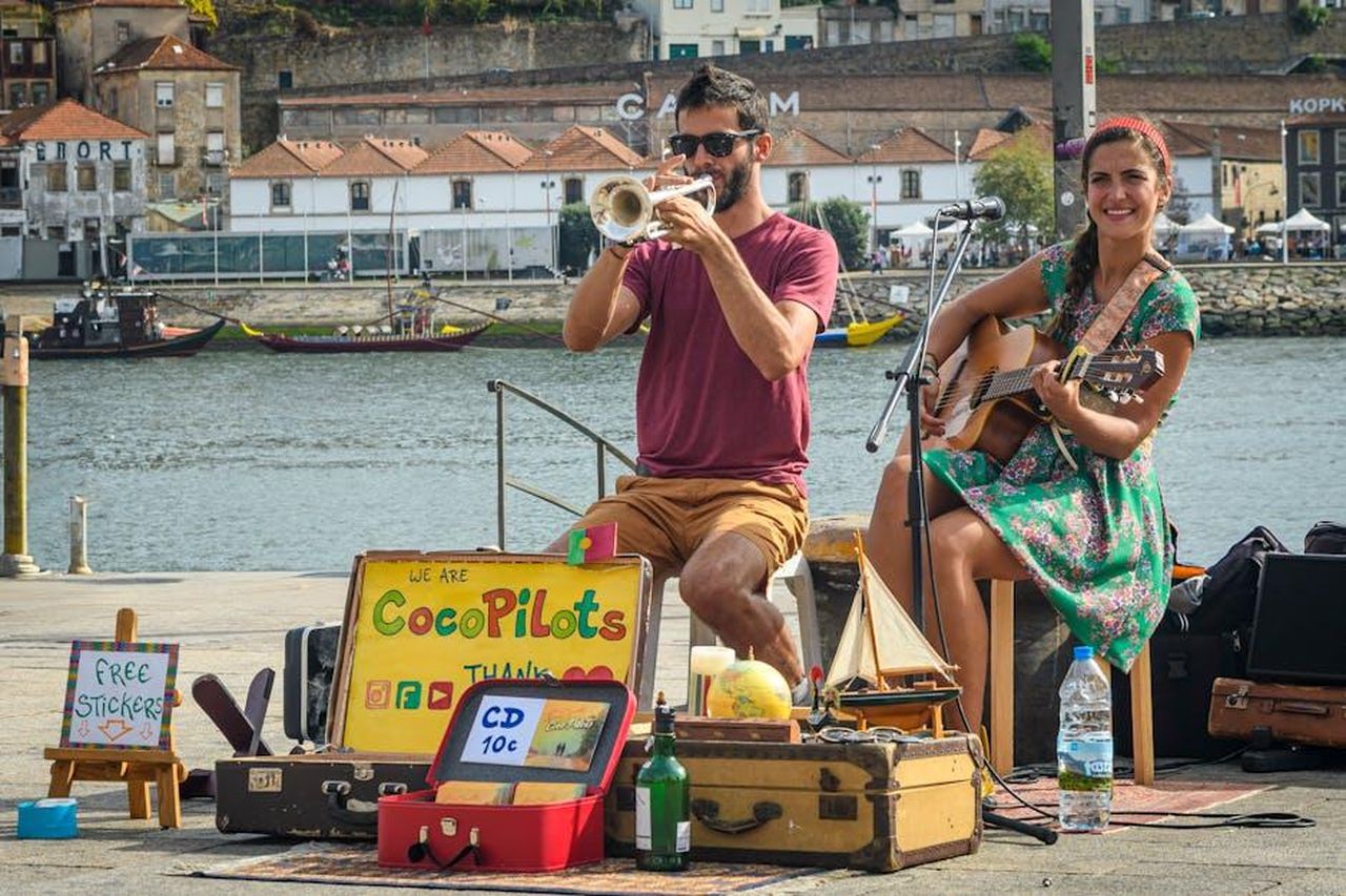 La_performance_di_Jessie_J_6VKyPFu766 - Confidenze24 Source: Ignacio de Lucas - pexels - Street musicians performing by the Douro River in Porto, creating a vibrant and lively atmosphere.