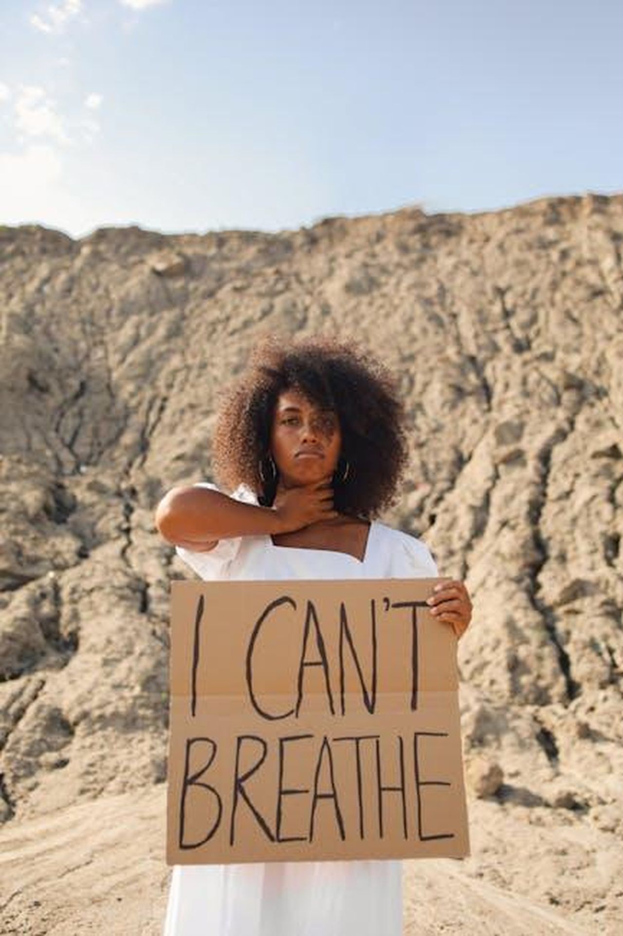 La_protesta_del_2020_e_il_contesto_0Sy8ZJOeyG - Confidenze24 Source: Polina Tankilevitch - pexels - Black woman in white dress holds 'I Can't Breathe' sign outdoors, symbolizing protest.