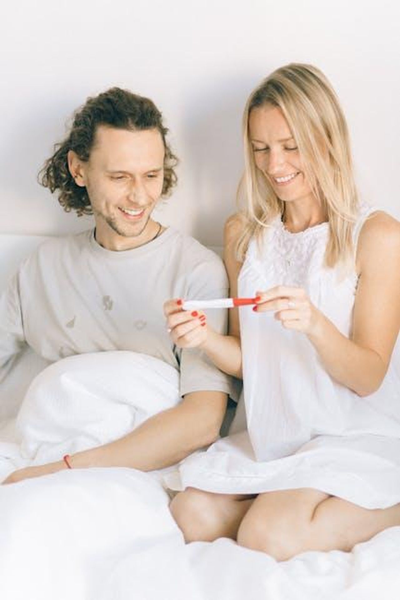 La_reazione_del_pubblico_alla_nuova_coppia_jRE1kJLkTF - Confidenze24 Source: Nataliya Vaitkevich - pexels - Happy couple sitting in bed, celebrating positive pregnancy test result.