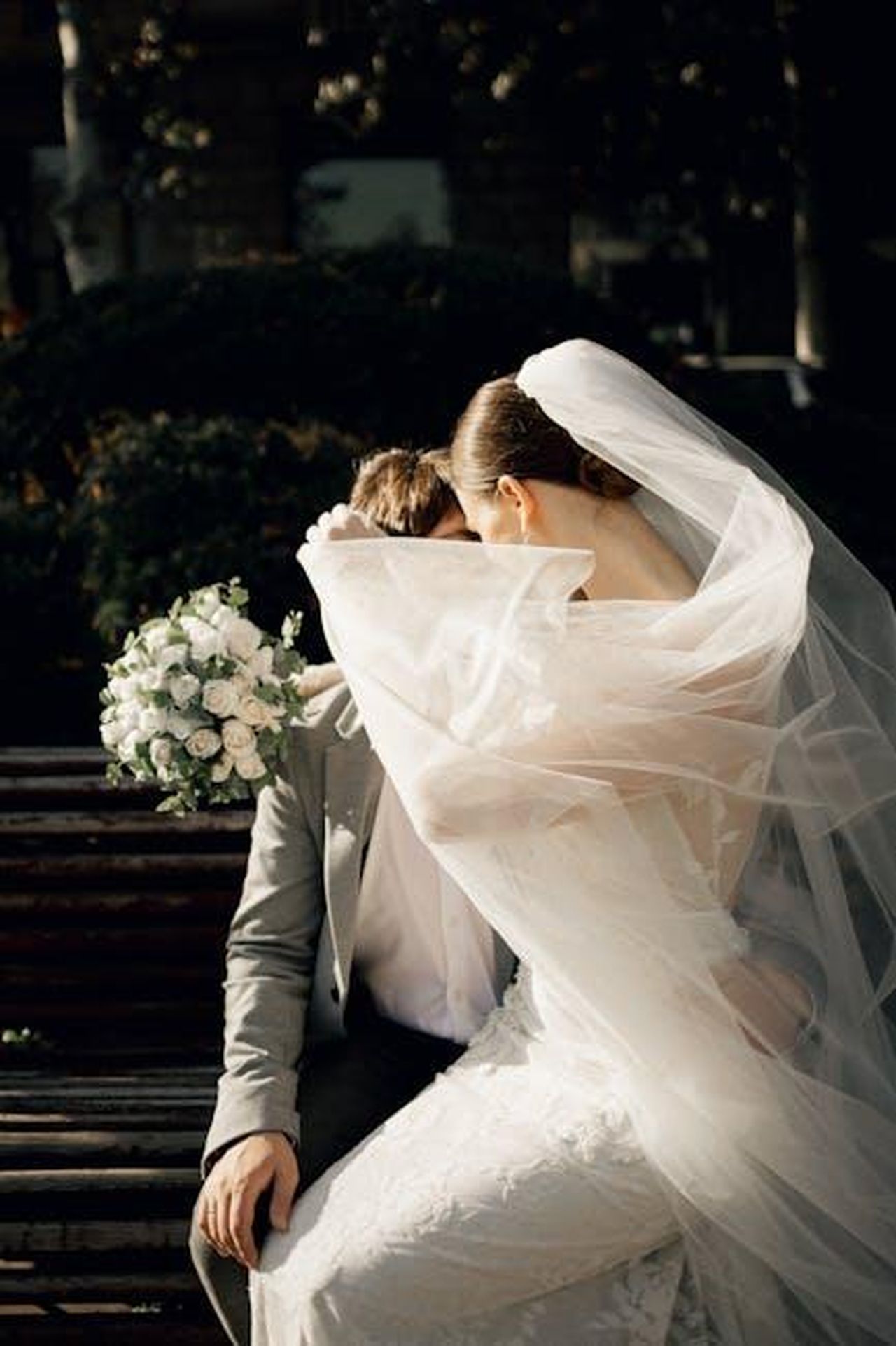 La_reazione_del_pubblico_e_dei_fan_faji1TY7qm - Confidenze24 Source: Rina Mayer - pexels - Newlywed couple in wedding attire sharing a tender moment on a park bench.