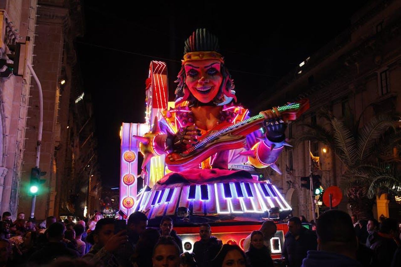 La_reazione_della_famiglia_Hutchins_alla_serie_TLC_tBooDkF9AW - Confidenze24 Source: Andrew Cutajar - pexels - Colorful neon-lit parade float featuring a giant musician and keyboard at night.