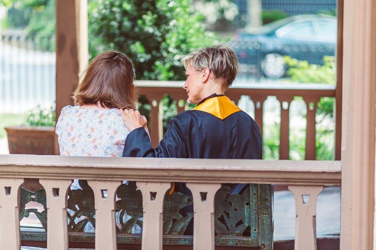 La_reazione_di_Arnold_Schwarzenegger_bDaVqM3EG2 - Confidenze24 Source: RDNE Stock project - pexels - A graduate in cap and gown shares a heartfelt moment with a loved one on a sunny outdoor porch.