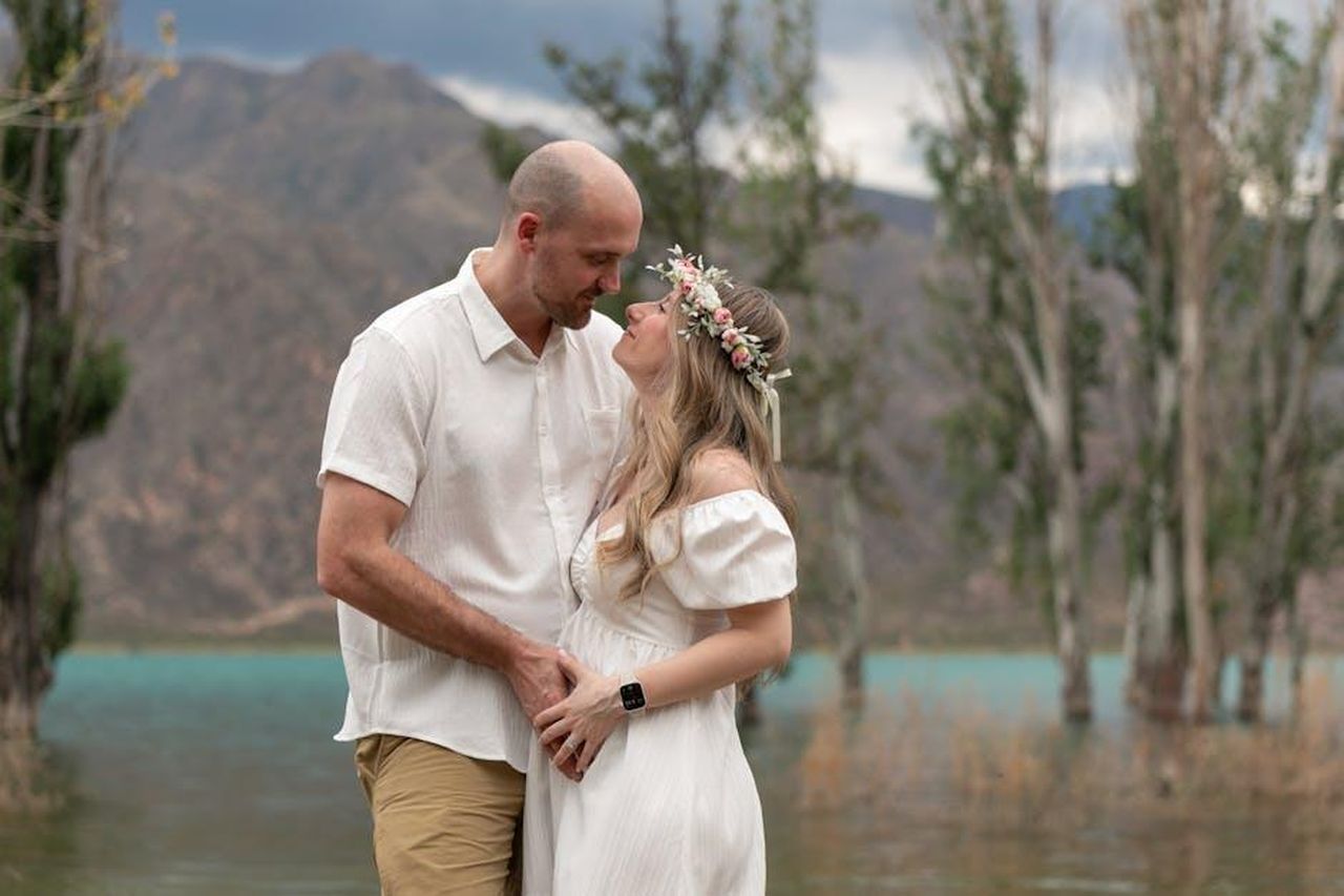 La_reazione_di_Green_alle_dichiarazioni_di_MGK_s0BD34KPIR - Confidenze24 Source: Lilen Diaz - pexels - A loving couple dressed in white embraces by a scenic lake in Mendoza, Argentina.