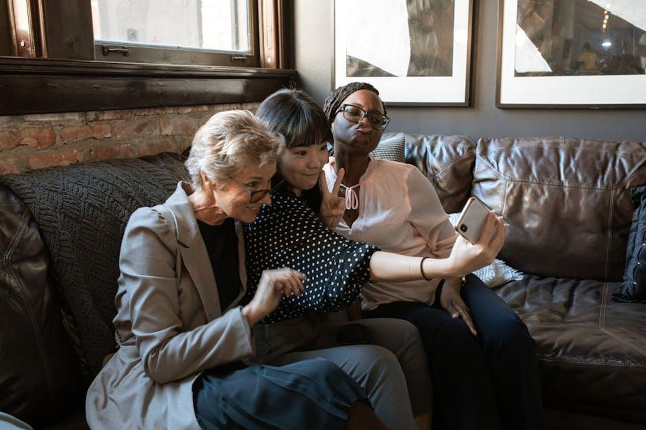 La_reazione_di_Jeff_Goldblum_allintervista_vxbyvFaQtr - Confidenze24 Source: RDNE Stock project - pexels - A group of diverse friends enjoying a selfie together on a cozy couch in a stylish interior.